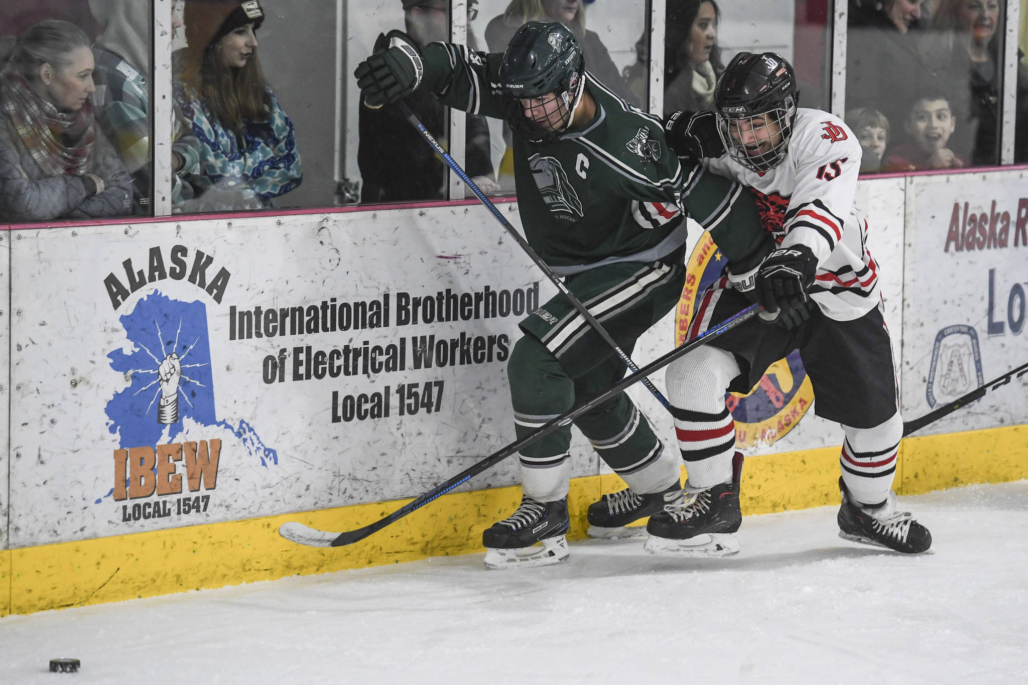 Juneau-Douglas’ Josh Frisby, right, competes against Colony’s Blake Reid for the puck at Treadwell Arena on Friday, Nov. 22, 2019. (Michael Penn | Juneau Empire)