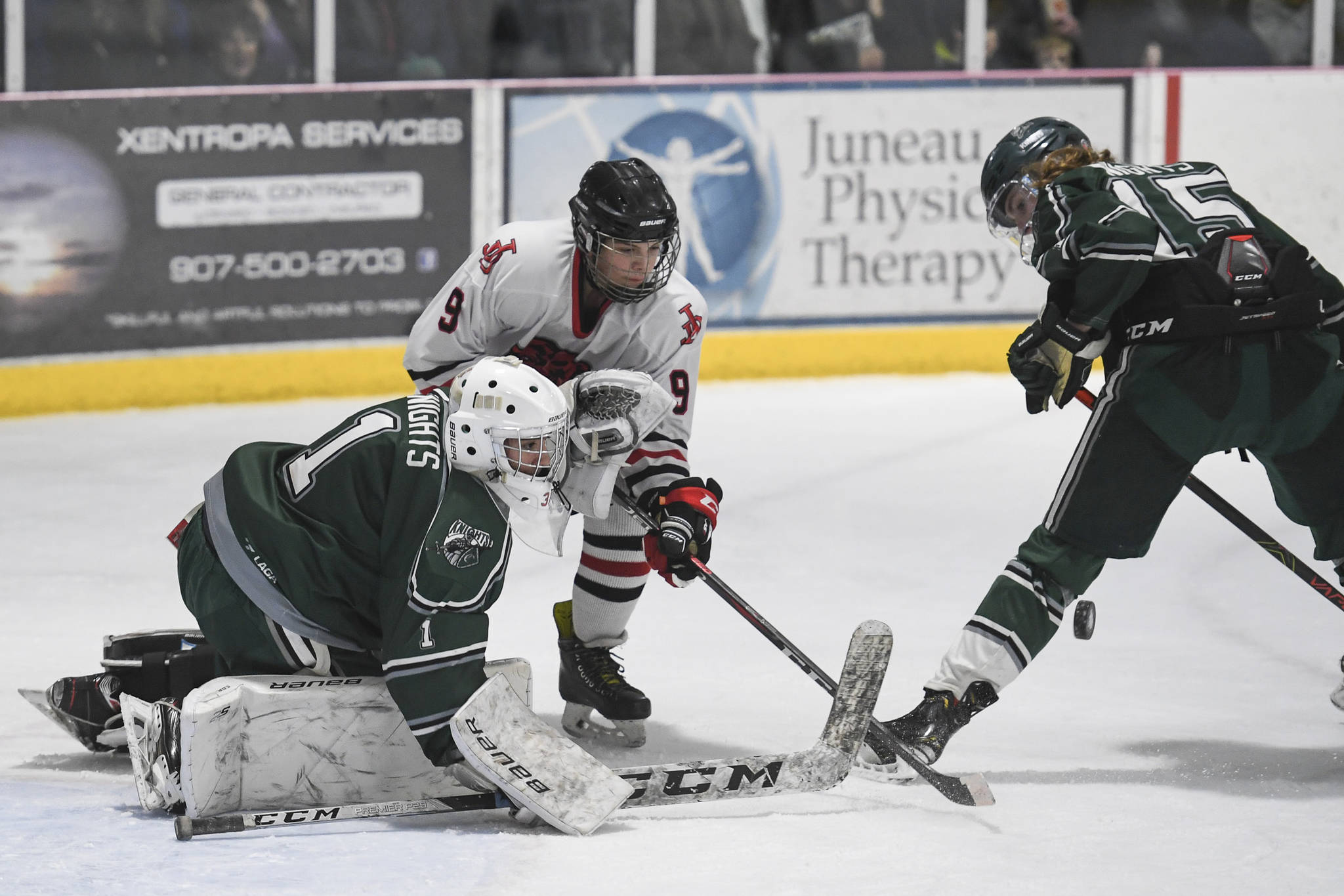 Juneau-Douglas’ Sam Bovitz competes against Colony’s goalkeeper Bryant Marks, left, and Carson McLaughlin for control of the puck at Treadwell Arena on Friday, Nov. 22, 2019. (Michael Penn | Juneau Empire)