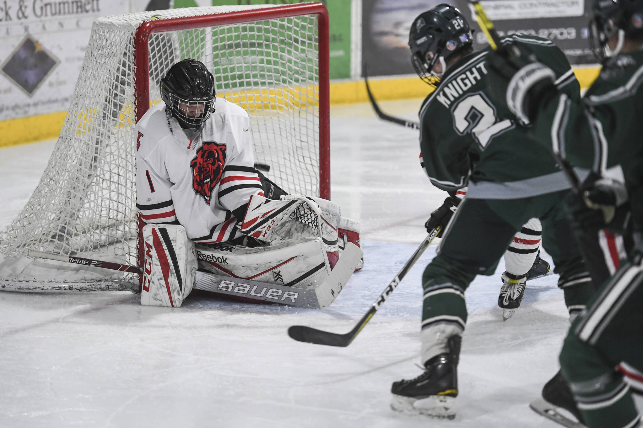 Colony’s Jacob Ross, right, gets the puck over Juneau-Douglas’ goalkeeper Cody Mitchell’s glove to score in the second period at Treadwell Arena on Friday, Nov. 22, 2019. (Michael Penn | Juneau Empire)