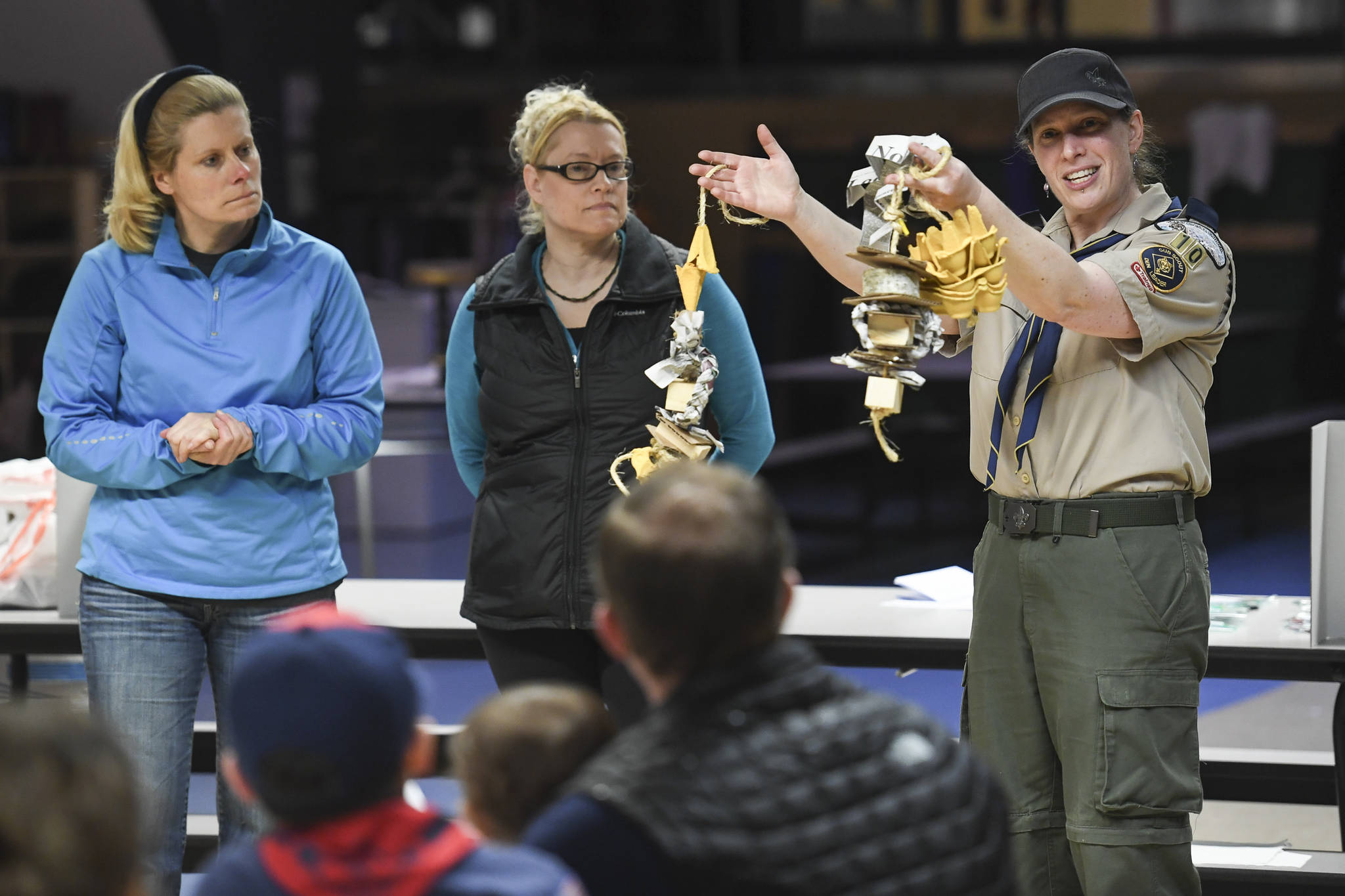 Bear Den Leader Shannon Seifert holds up examples enrichment toys for birds during a cub scout pack meeting at Harborview Elementary School on Friday, Nov. 22, 2019. About 25 cub scouts constructed the toys as a service project for the Juneau Raptor Center. (Michael Penn | Juneau Empire)