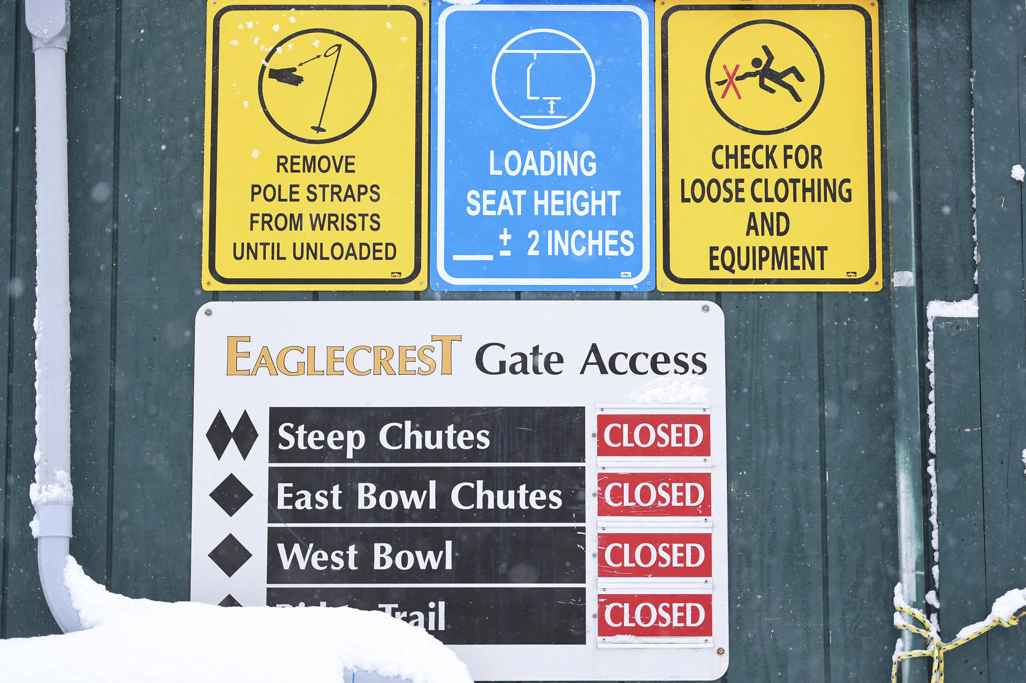 Snow and signs at the base of the Ptarmigan Chairlift on Tuesday, Dec. 3, 2019. (Michael Penn | Juneau Empire)