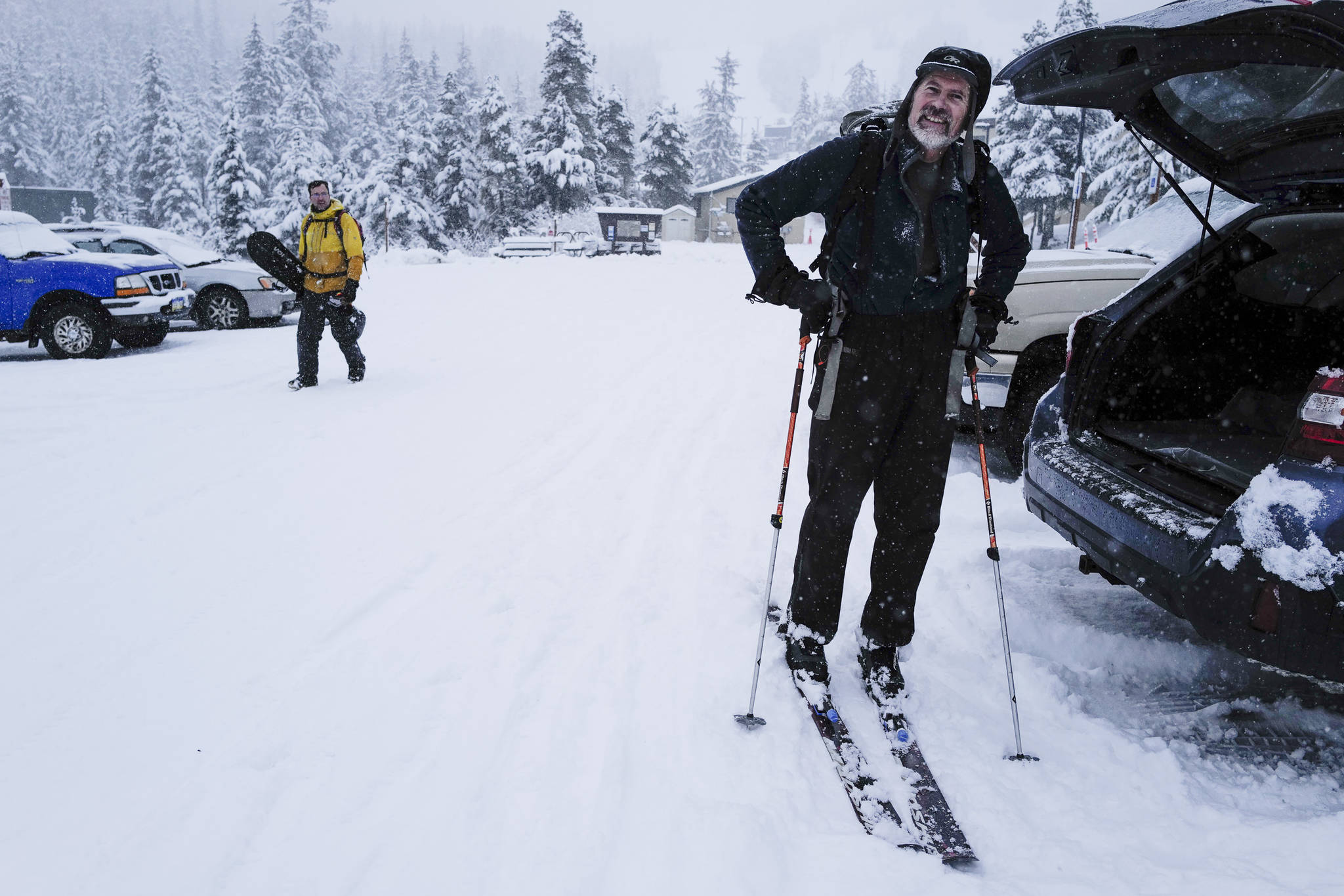 Eric Kueffner, right, and Wade Pancich return to their vehicles after taking advantage of fresh snow at Eaglecrest on Tuesday, Dec. 3, 2019. (Michael Penn | Juneau Empire)