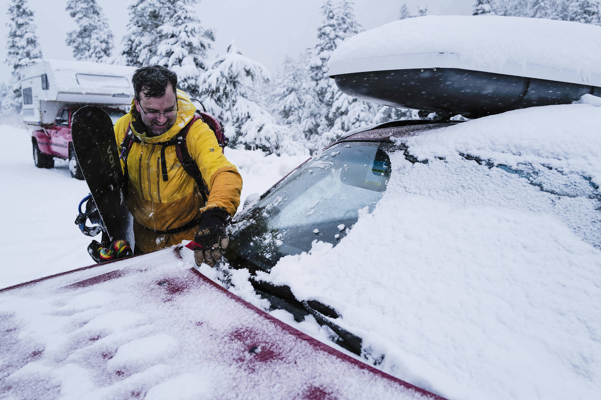 Snowboarder Wade Pancich cleans fresh snow off his windshield after returning from making a few turns at Eaglecrest on Tuesday, Dec. 3, 2019. (Michael Penn | Juneau Empire)