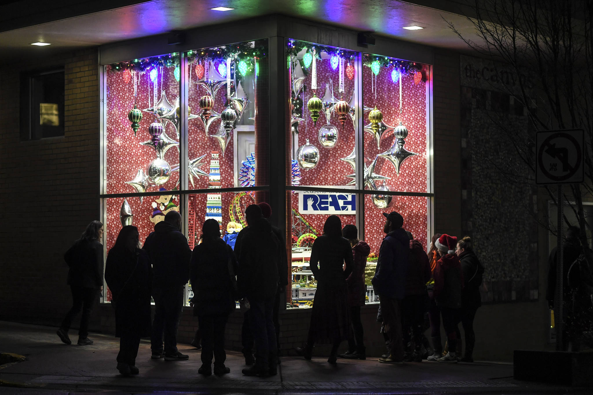 Juneau residents take in the decorated window display at REACH during Gallery Walk on Friday, Dec. 6, 2019. (Michael Penn | Juneau Empire)