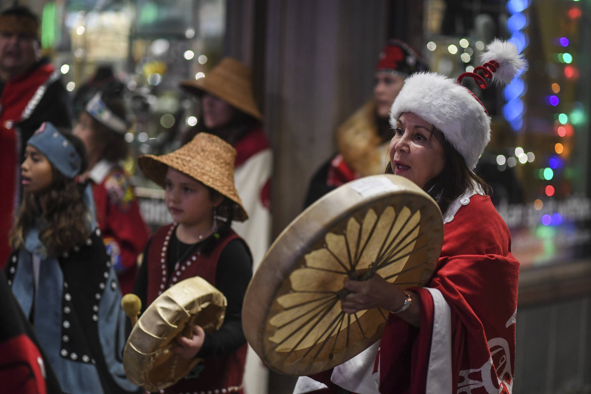 Nancy Barnes leads the Yees ku.oo Dancers in a song on Front Street during Gallery Walk on Friday, Dec. 6, 2019. (Michael Penn | Juneau Empire)
