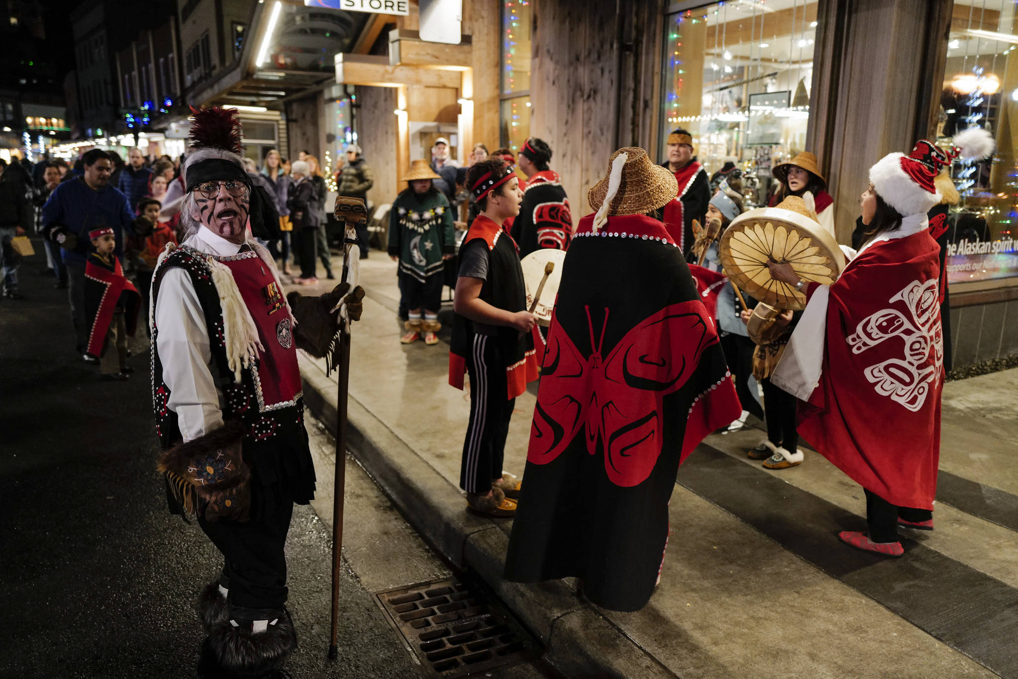 Walter Soboleff, left, sings with the Yees ku.oo Dancers on Front Street during Gallery Walk on Friday, Dec. 6, 2019. (Michael Penn | Juneau Empire)