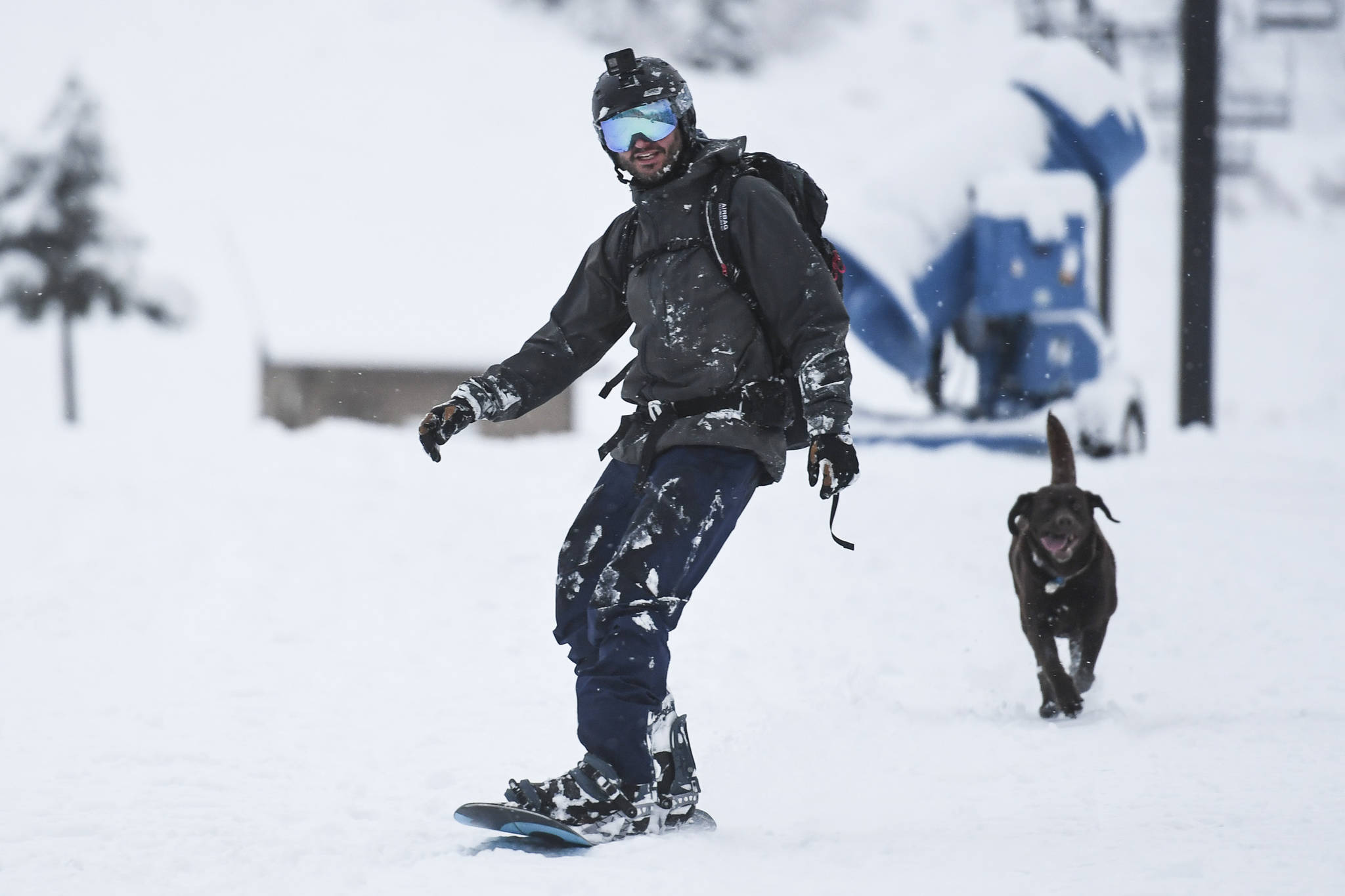 Chris Miller is followed by Izzy as he snowboards at Eaglecrest on Tuesday, Dec. 3, 2019. (Michael Penn | Juneau Empire)