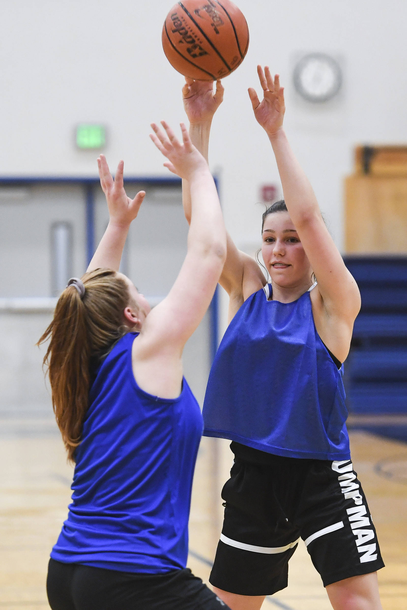 Riley Traxler, right, passes over Sydney Strong during the girls varsity basketball practice at Thunder Mountain High School on Monday, Dec. 9, 2019. (Michael Penn | Juneau Empire)