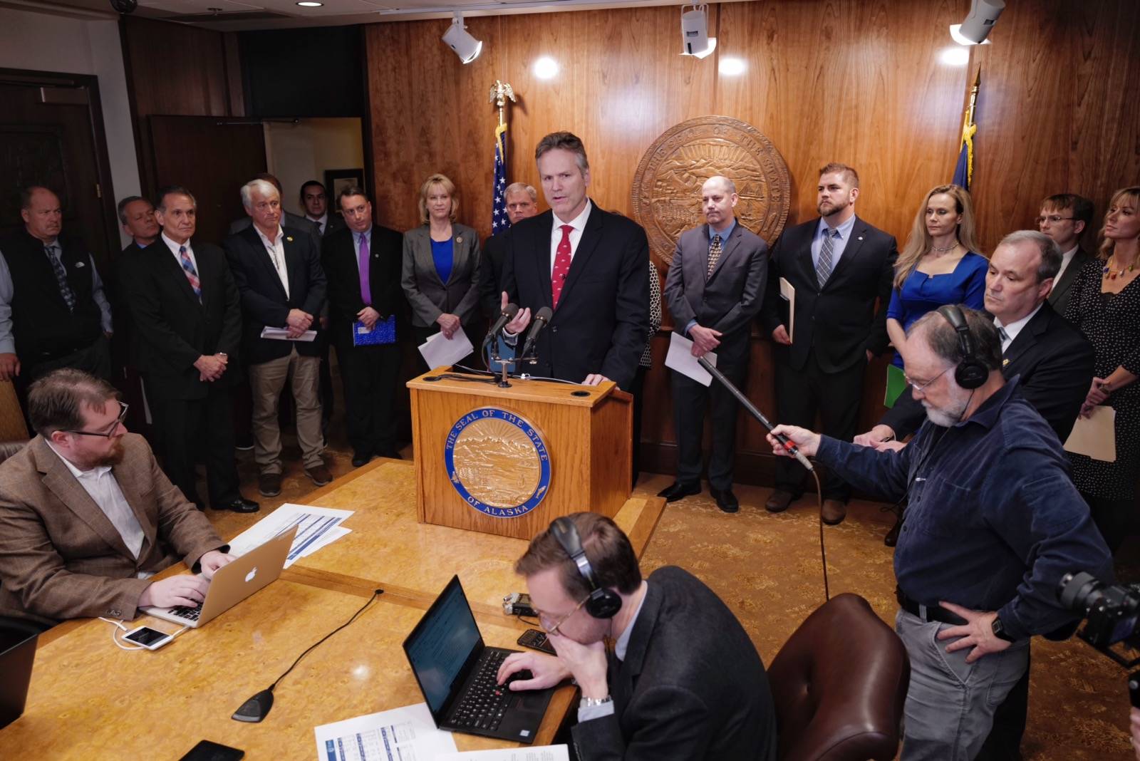 Gov. Mike Dunleavy, surrounded by his cabinet members, announces his state budget during a press conference at the Capitol on Wednesday, Dec. 11, 2019. (Michael Penn | Juneau Empire)