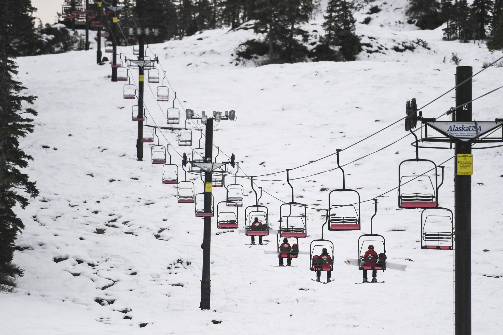 Ski patrollers ride the Hooter Chairlift as they work at Eaglecrest Ski Area on Thursday, Dec. 12, 2019. (Michael Penn | Juneau Empire)