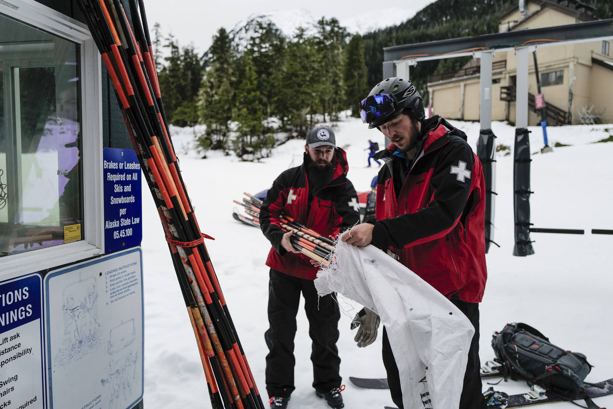 Ski Patrollers Tucker Cooper, left, and Calder Otsea bag bamboo hazard markers at Eaglecrest Ski Area on Thursday, Dec. 12, 2019. (Michael Penn | Juneau Empire)