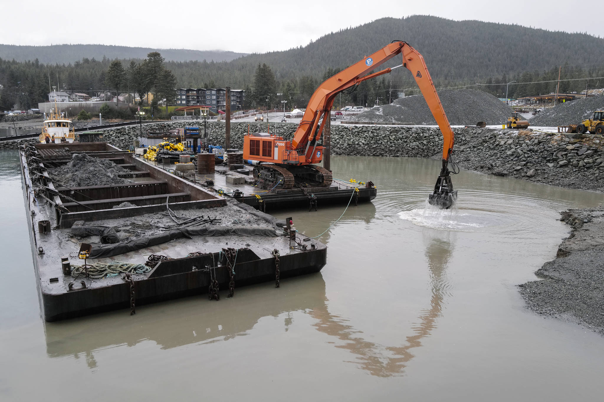 Dredging continues in the basin at the Don D. Statter Memorial Boat Harbor in Auke Bay on Wednesday, Dec. 18, 2019. The area will be used to construct floats for the charter vessel fleet. The floats will be in use by the whale watching charters in May of 2021. (Michael Penn | Juneau Empire)