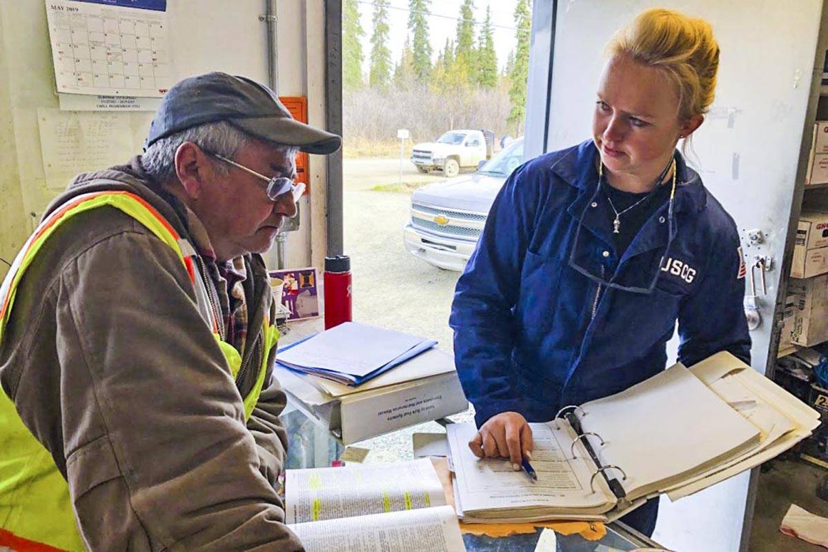 Petty Officer 3rd Class Holly Hugunin, an inspector with Coast Guard Sector Anchorage, works with Kenny Morgan, a Morgan Fuels facility manager in Kalskag, Alaska, May 16, 2019. (Lt. Cmdr. David Evans | U.S. Coast Guard)