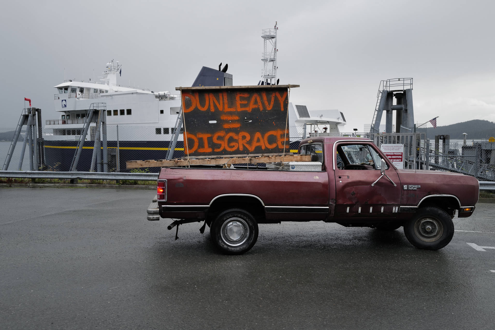 Mike Forrest displays his homemade sign at the Auke Bay Terminal after the Alaska Region of the Inland Boatman’s Union of the Pacific went on strike on Wednesday, July 24, 2019. (Michael Penn | Juneau Empire)