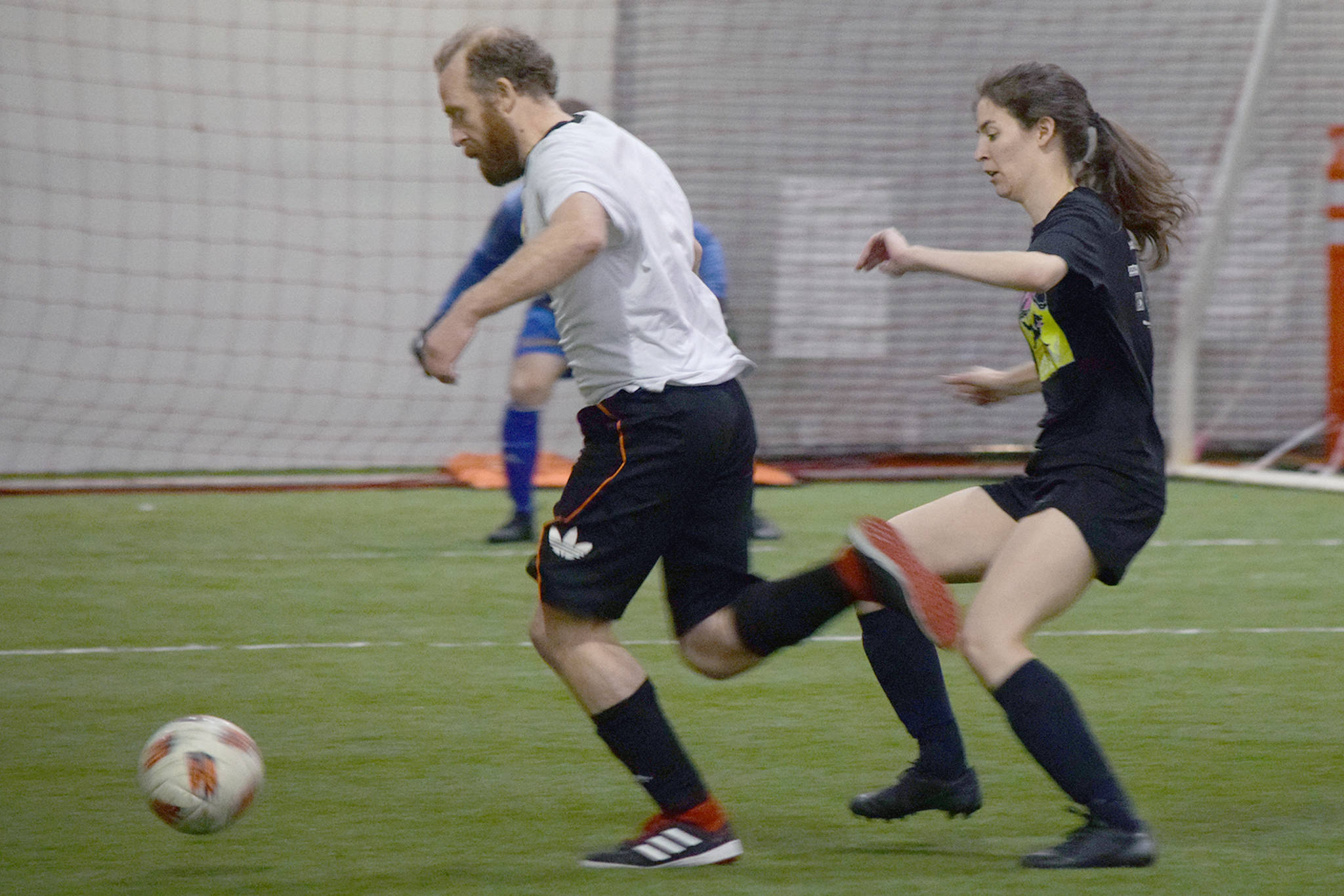 Some Stars’ Pat Race, left, dribbles the ball in front of Goal Patrol’s Elisha Thibodeau during the championship game of the Masters Division of the Holiday Cup at the Dimond Park Field House on Tuesday, Dec. 31, 2019. Some Stars defeated Goal Patrol 5-3. (Nolin Ainsworth | Juneau Empire)