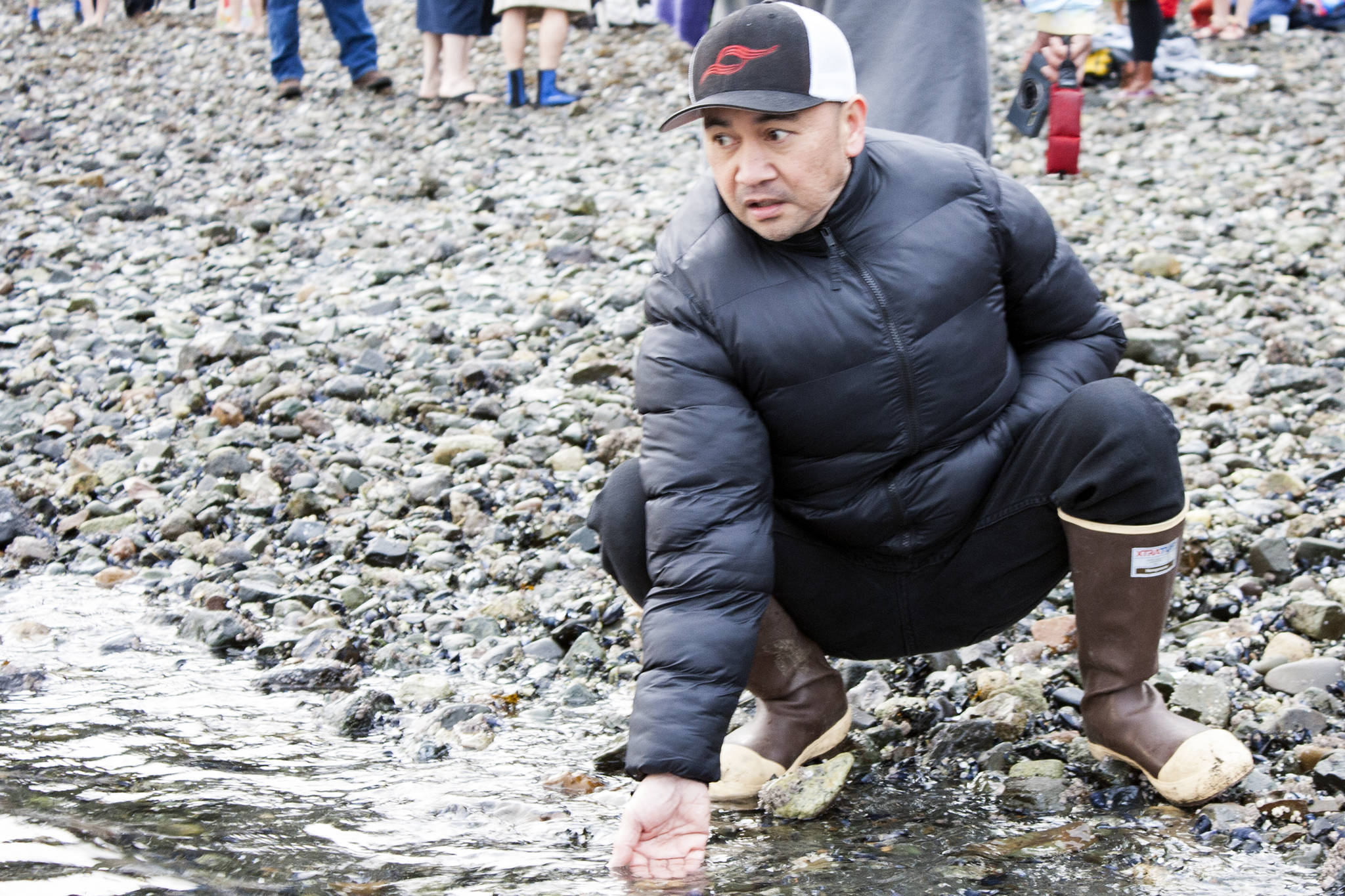 Ionel Casulucan checks the temperature of the water at Auke Bay Recreation Area on Wednesday, Jan. 1, before the 2020 Polar Dip. (Ben Hohenstatt | Juneau Empire)