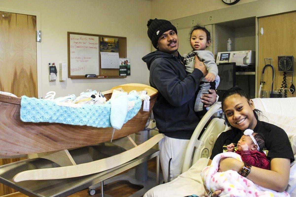 Marcella Poloa amd Ronnie Maae pose with newborn daughter, Ronarielle Poloa-Maae, the first baby born in Juneau in 2020, and her older brother, JR, alongside a wooden rocking boat crafted by Dr. Lindy Jones for the first baby of the year, Jan. 1, 2020. (Courtesy Photo | Bartlett Regional Hospital)