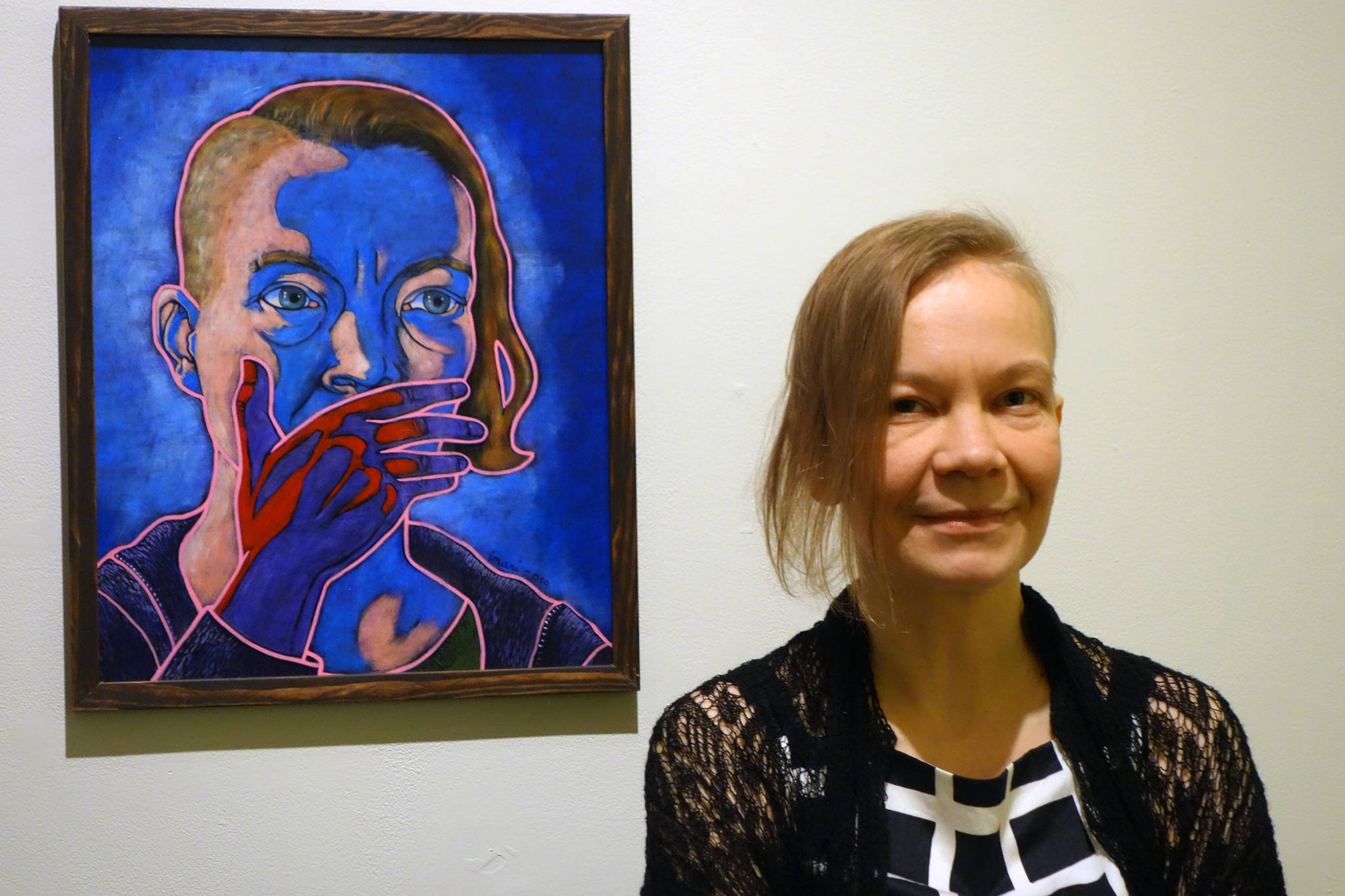 Ben Hohenstatt | Capital City Weekly                                Inari Kylänen stands near her painting, “Act of Doing Nothing is Still an Act II The Southern Border” during an opening reception for the new exhibition “A Nation of Immigrants” on Friday at the Juneau-Douglas City Museum.