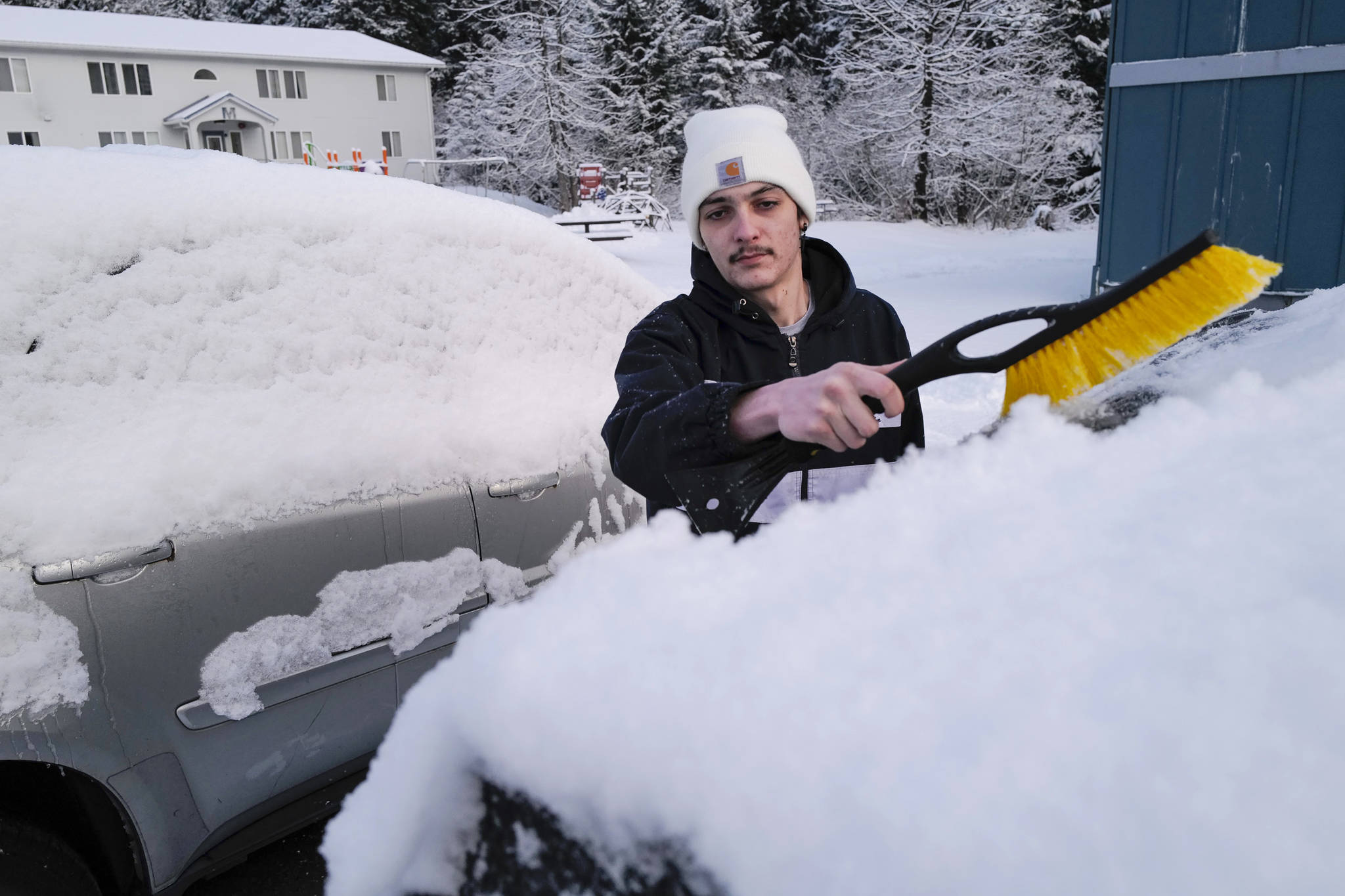Tommy Reber cleans a fresh coat of snow off his vehicle at Gruening Park on Monday, Jan. 6, 2020. (Michael Penn | Juneau Empire)