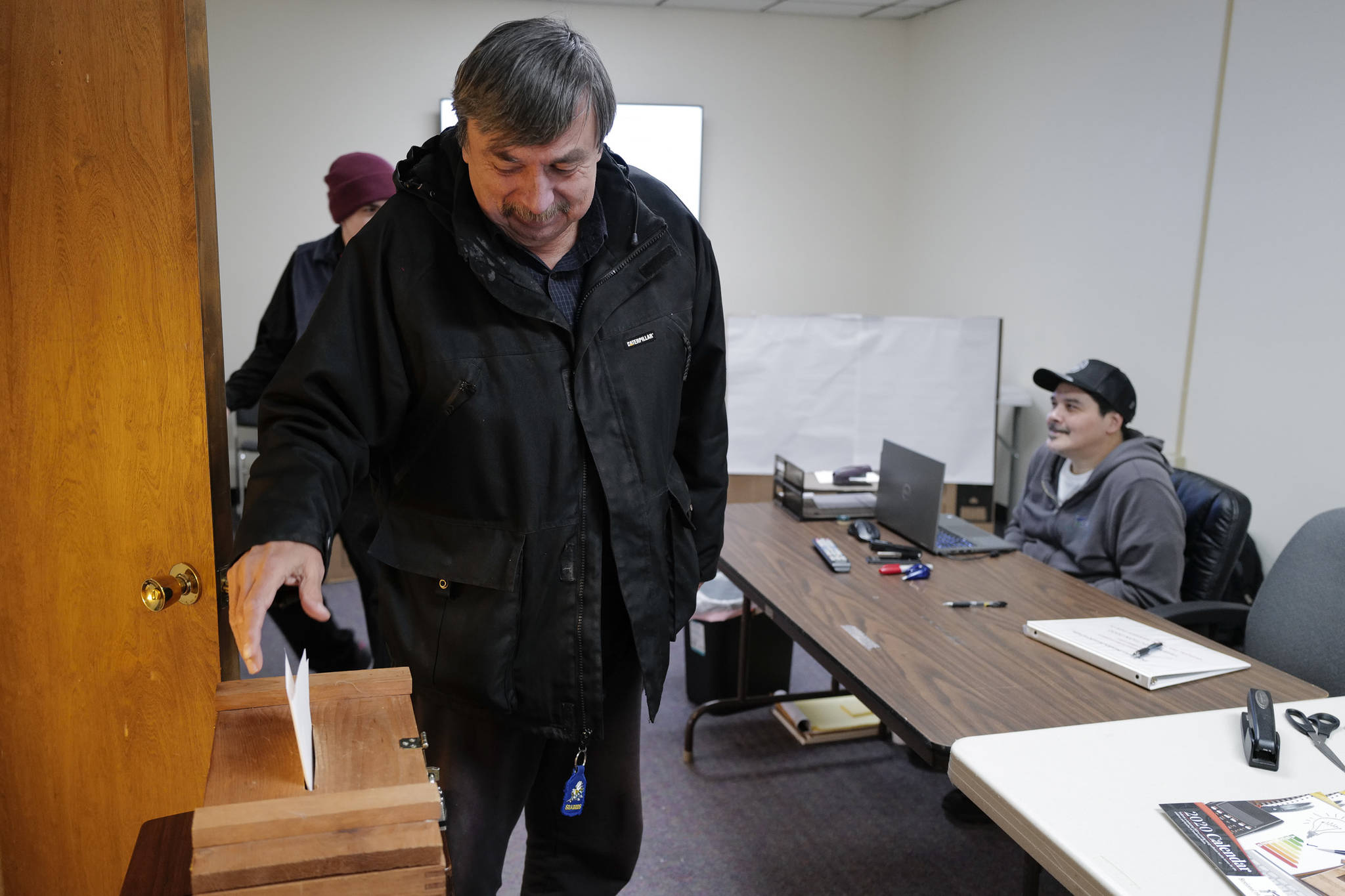 Ron Laiti drops his ballot into a ballot box after voting in the Douglas Indian Associations election on Wednesday. (Michael Penn | Juneau Empire)