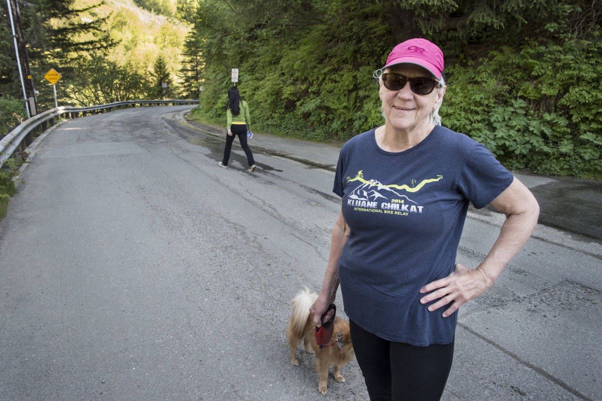Kim Metcalfe walks her dog along Basin Road on Tuesday, May 21, 2019. (Michael Penn | Juneau Empire File)