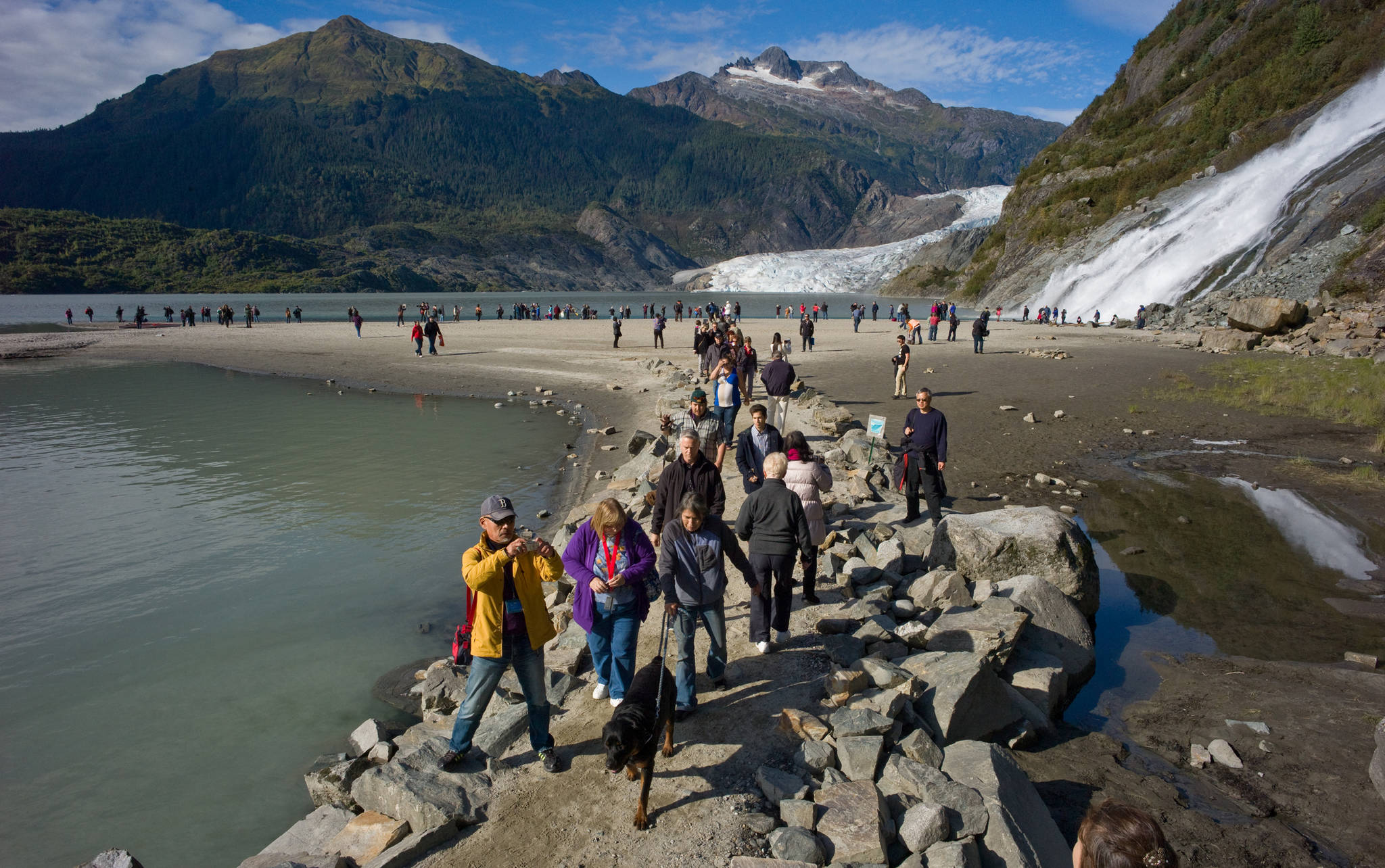 Tourists visit Nugget Falls in September 2014. (Michael Penn | Juneau Empire File)