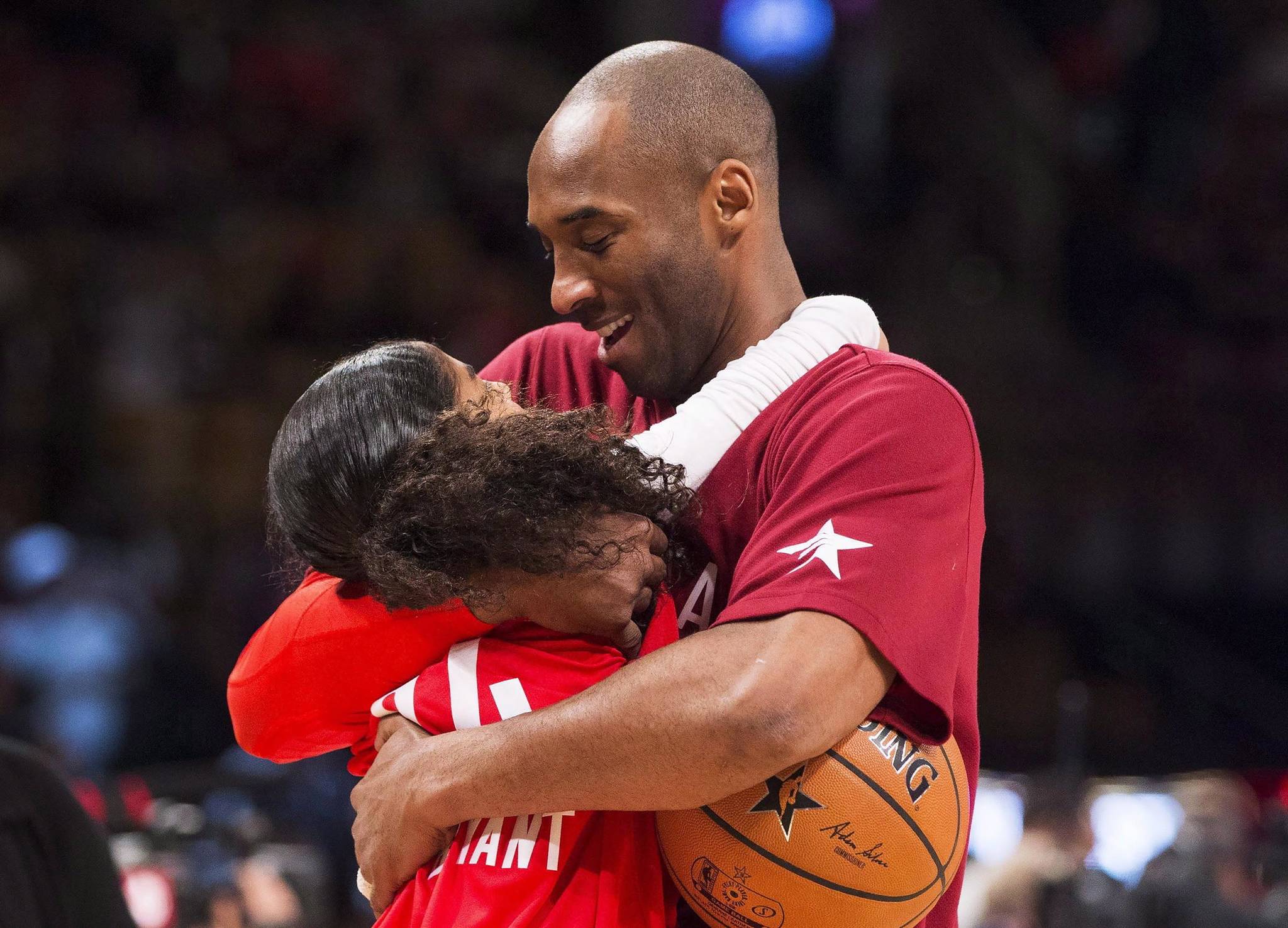 In this Feb. 14, 2016, file photo, Los Angeles Lakers Kobe Bryant (24) hugs his daughter Gianna on the court in warm-ups before first half NBA All-Star Game basketball action in Toronto. Bryant, his 13-year-old daughter, Gianna, and several others are dead after their helicopter went down in Southern California on Sunday, Jan. 26, 2020. (Mark Blinch | The Canadian Press via AP)