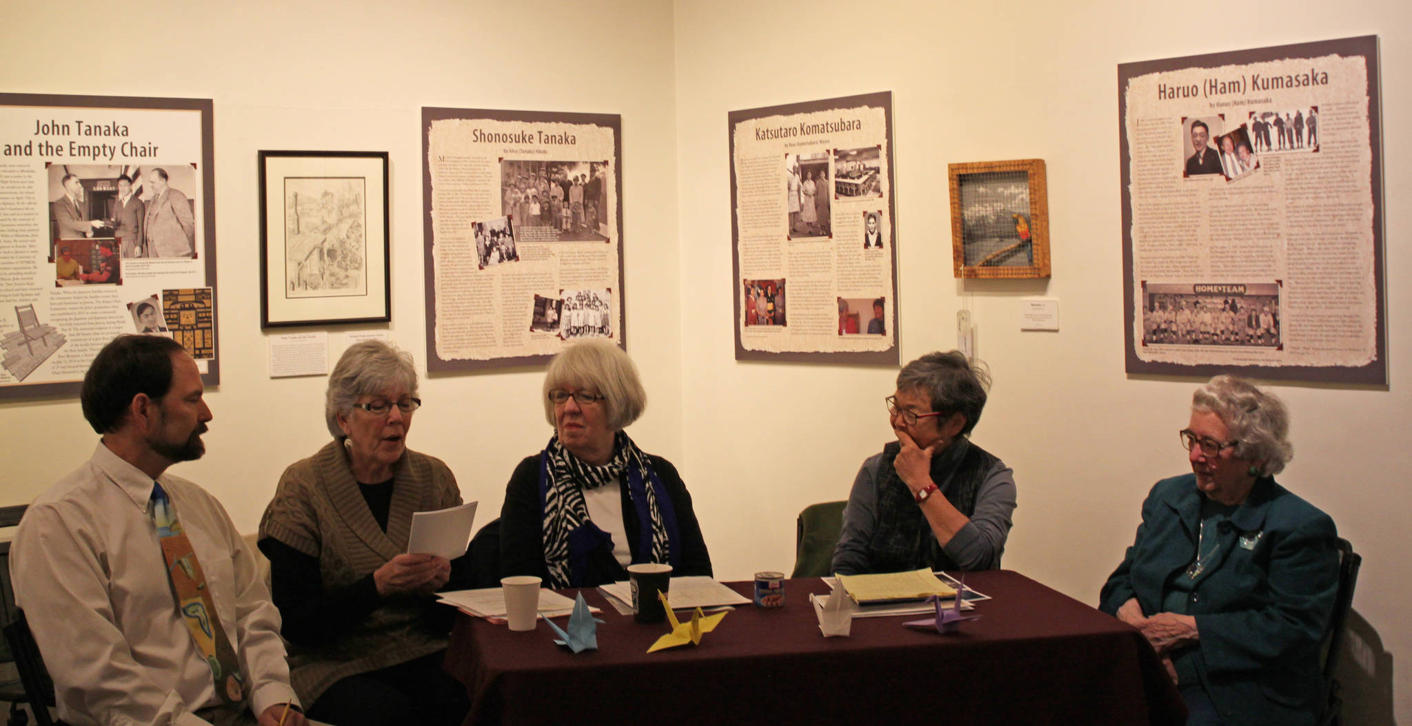 From right to left, Gary Chaney, Karleen Grummett, Marjorie Alstead Shakelford, Mary Tanaka Abo and Marie Darlin discuss the “Empty Chair” exhibit at the Juneau-Douglas City Museum on Saturday, Oct. 11, 2014. (Stephanie Shor | Juneau Empire)