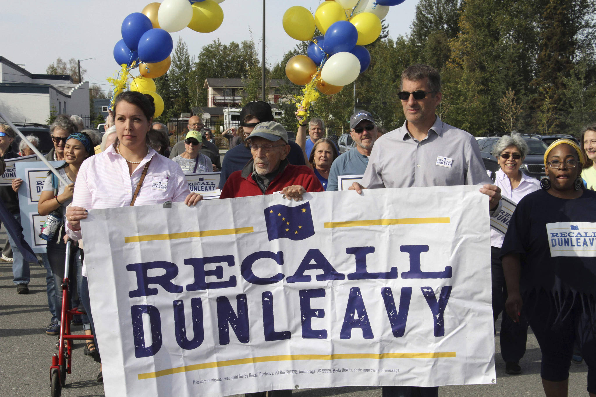 In this Sept. 5 file photo, Meda DeWitt, left, Vic Fischer, middle, and Aaron Welterlen, leaders of an effort to recall Gov. Mike Dunleavy, lead about 50 volunteers in a march to the Alaska Division of Elections office in Anchorage. The Alaska Supreme Court on Friday agreed to allow a group seeking to recall Gov. Mike Dunleavy to begin a second signature-gathering phase. (AP Photo | Mark Thiessen)