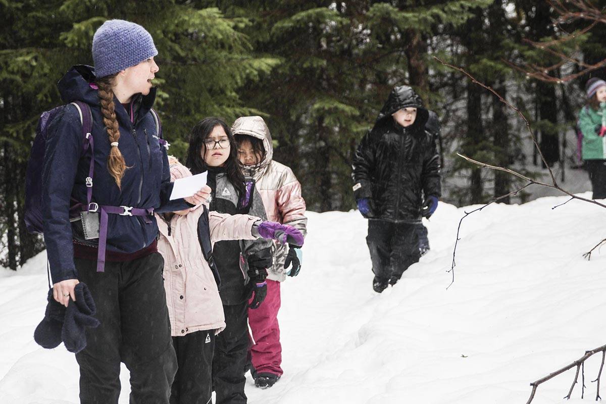 Discovery Southeast naturalist Bess Crandall talks to a group of 2nd graders from Harborview Elementary School about the states of water during a nature hike near the Mendenhall Glacier Visitor Center on Feb. 20, 2020. (Michael S. Lockett | Juneau Empire)
