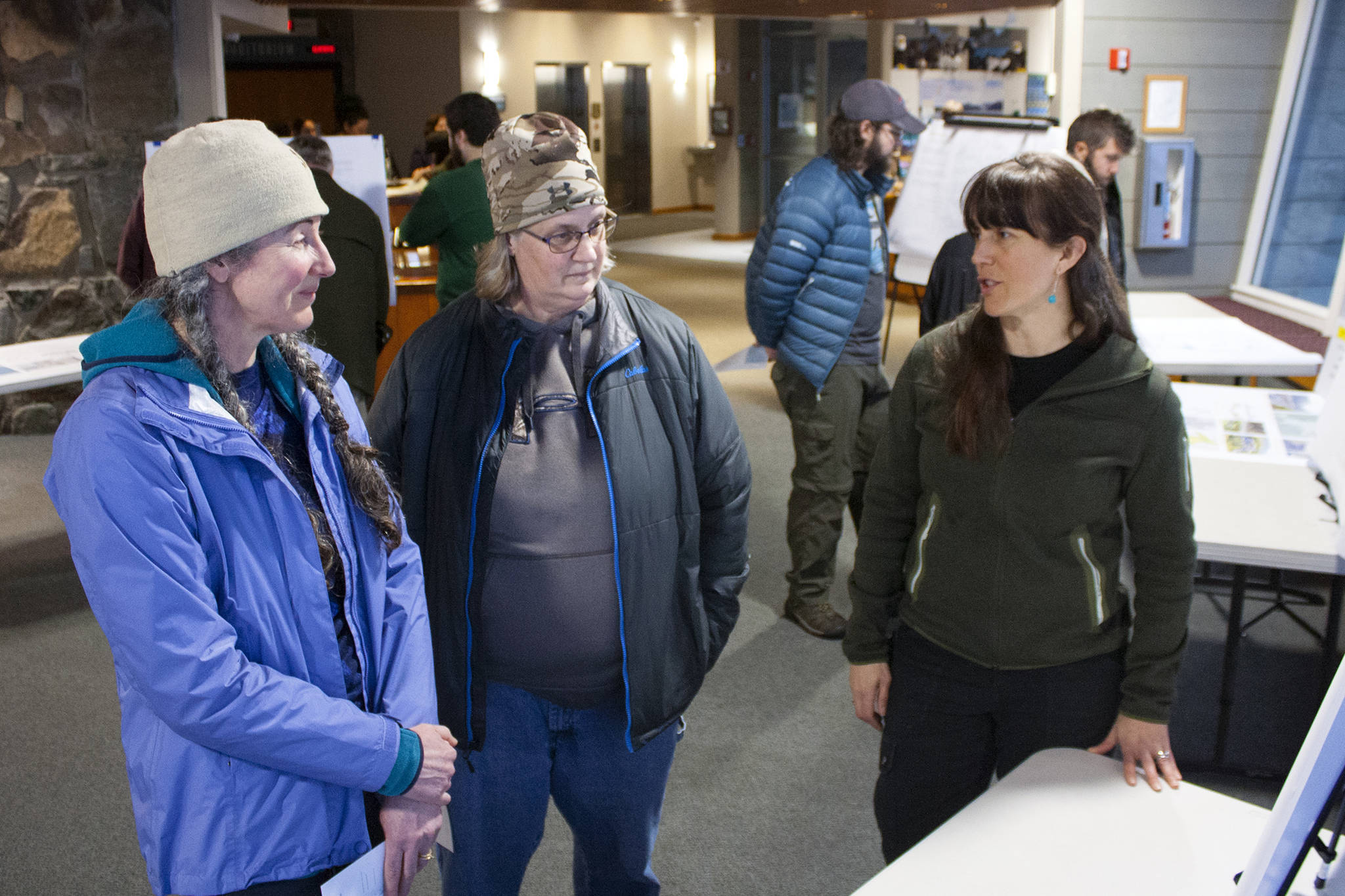 Pam Kihlmire and Elizabeth Flory talk with Dani Snyder, Tongass National Forest landscape architect, during an open house Thursday night at Mendenhall Glacier Visitor Center. (Ben Hohenstatt | Juneau Empire)