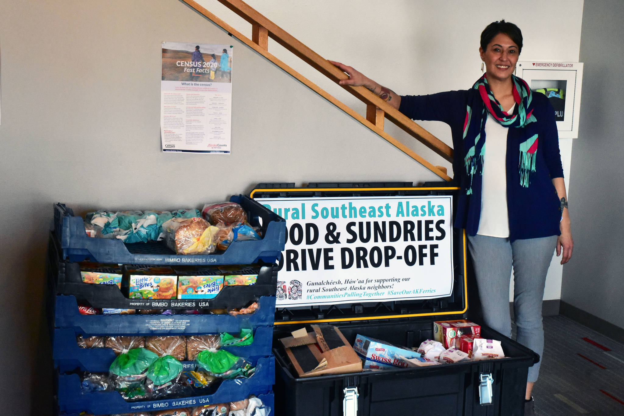 Jamiann Hasselquist, administrative assistant at Central Council of Tlingit and Haida Indian Tribes of Alaska next to food donation bins for rural communities in Southeast Alaska affected by lack of ferry service on Thursday, Feb. 27, 2020. (Peter Segall | Juneau Empire)