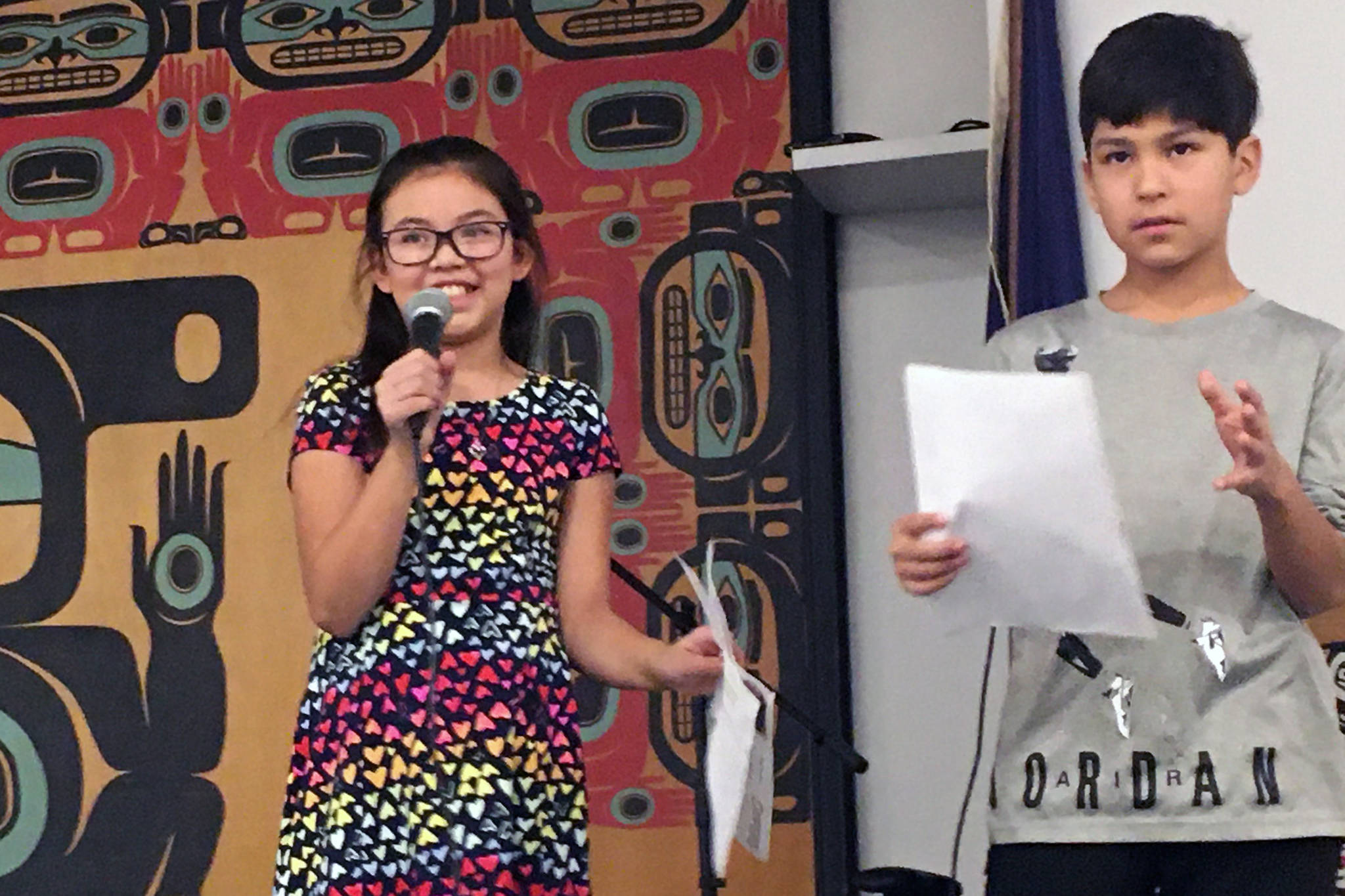 Glacier Valley Elementary School Sít’ Eetí Shaanáx students Faith Contreras and Johnny Hunter, who are both Tlingit, present at the Central Council of Tlingit and Haida Indian Tribes of Alaska elder’s luncheon. They collected 64 signatures at the luncheon in support of officially adding a second verse to the state song, “Alaska’s Flag.” Students say the new verse is culturally inclusive. (Courtesy Photo | Lorrie Heagy)