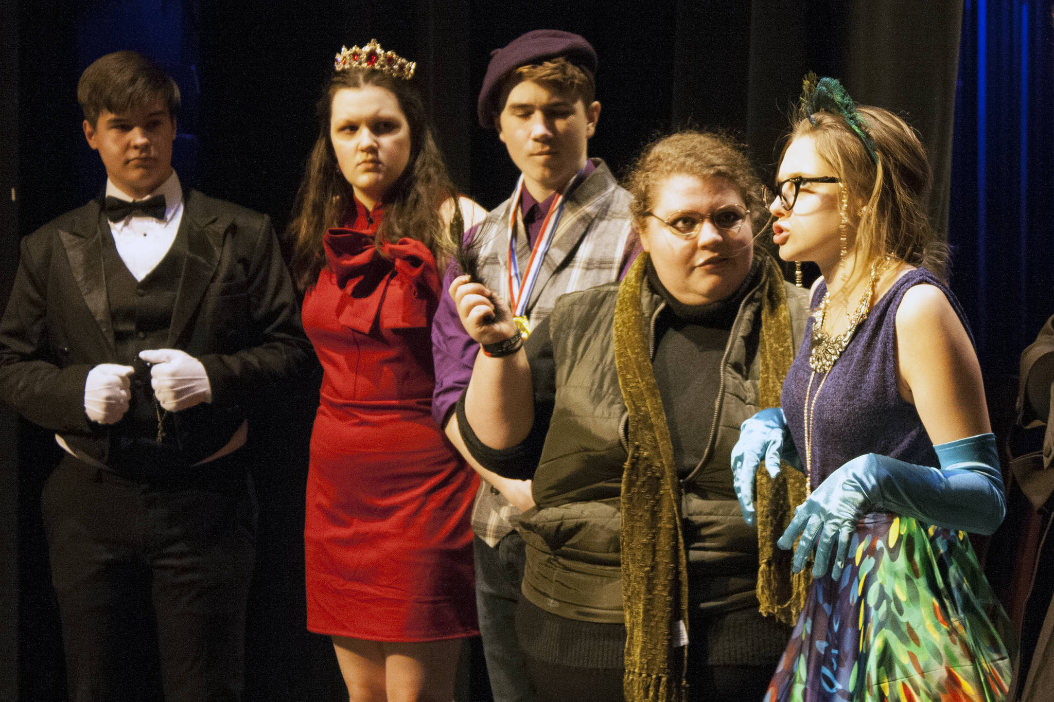Mr. Green (Aria Moore) makes a serious accusation about Mrs. Peacock (Kayla Kohlhase) while holding a feather. A surprised Wadsworth (Toby Russell), Miss Scarlet (Amanda McDowell) and Professor Plum (Jager Hunt) look on. (Ben Hohenstatt | Juneau Empire)