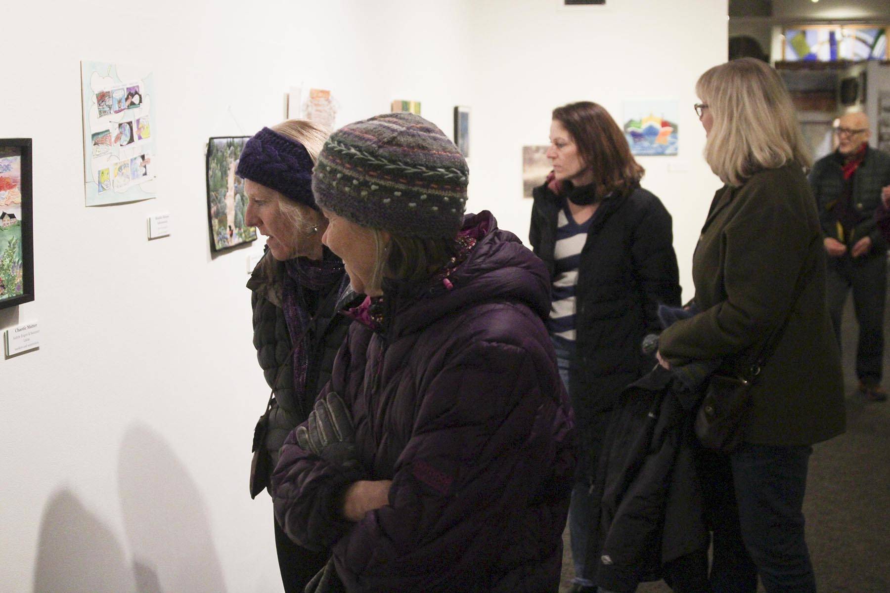 Guests look at the 12x12 art exhibits at the Juneau-Douglas City Museum.