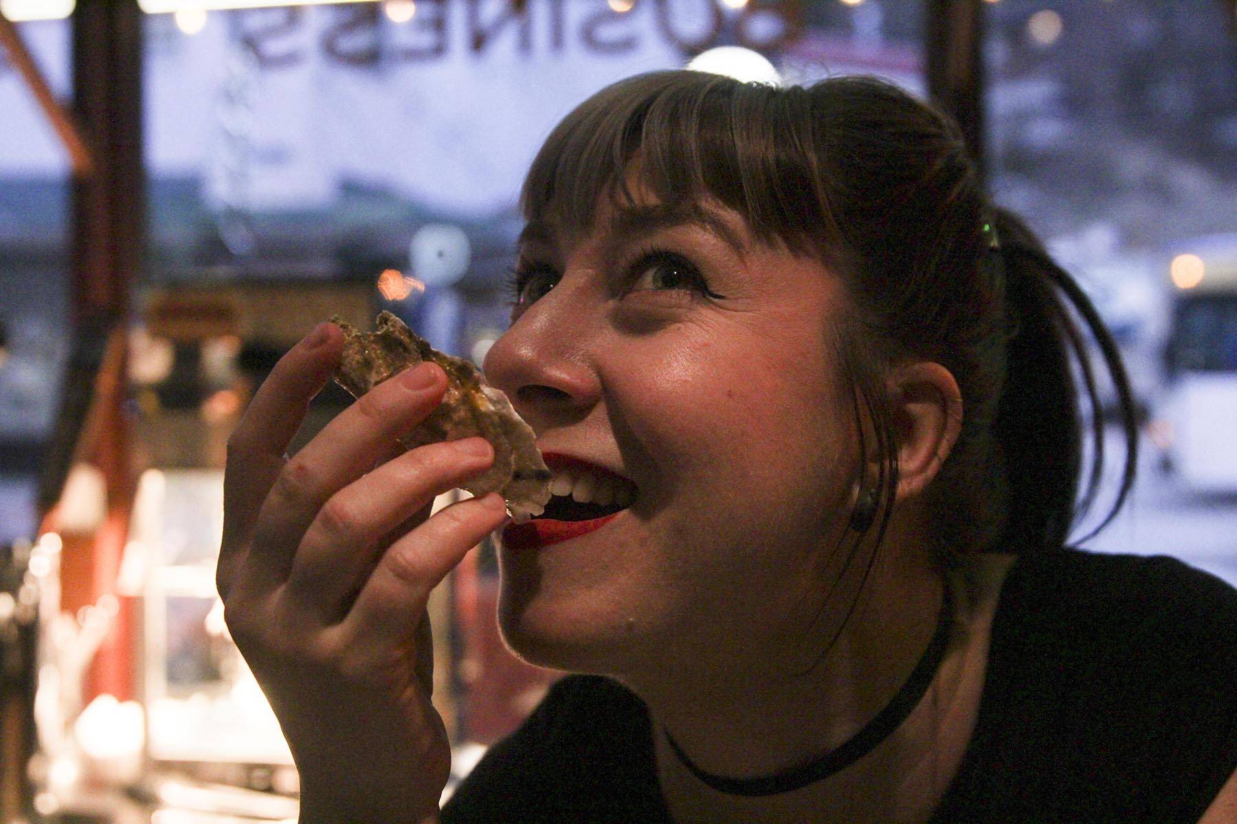 Bonilyn Parker shoots an oyster at the Triangle Club on First Friday.