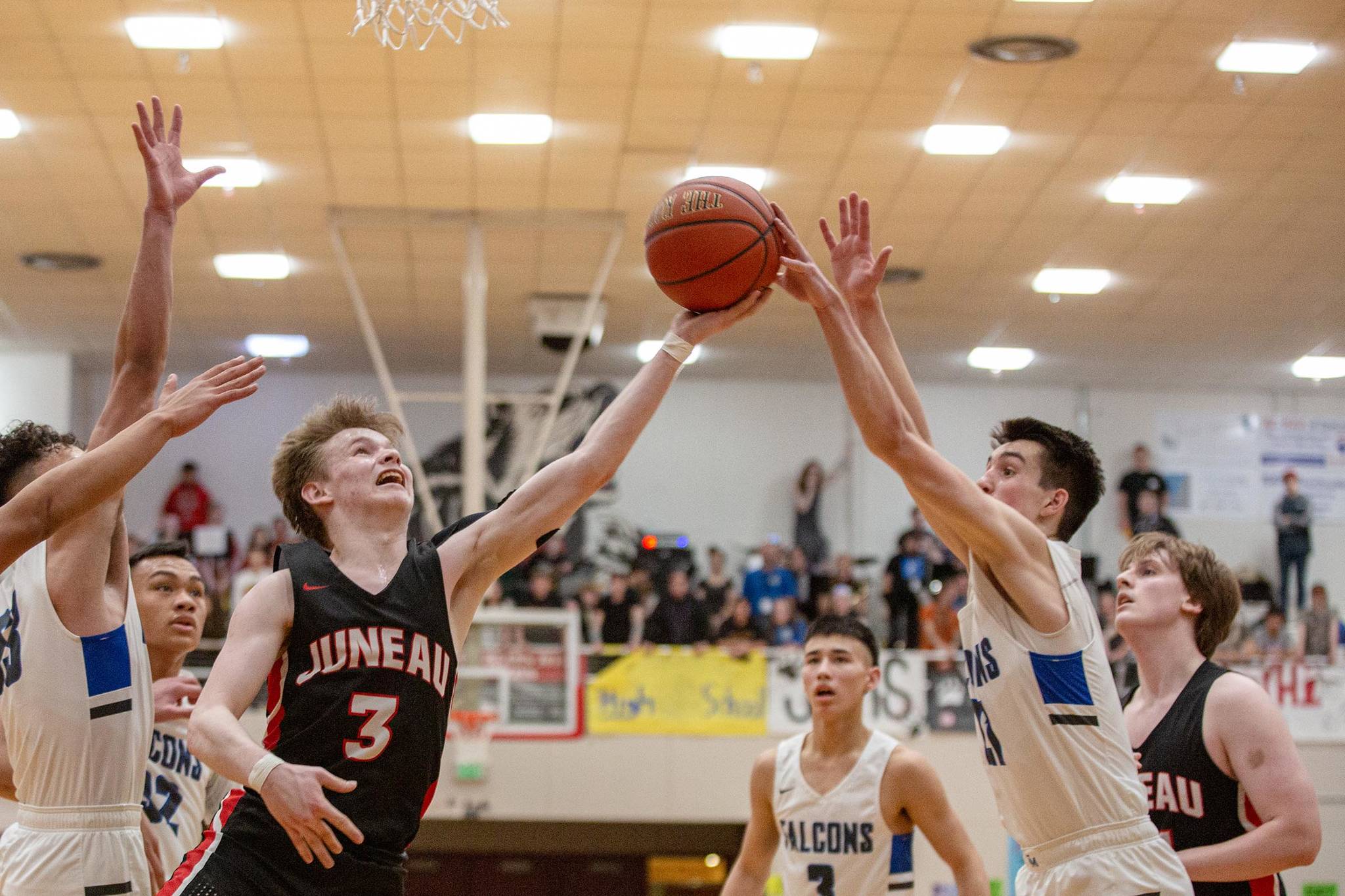 JDHS’ Austin McCurley drives to the hoop and is met by TMHS’ Braden Jenkins in a closely contested Region V tournament championship game between Juneau-Douglas High School: Yadaa.at Kalé and Thunder Mountain High School. (Courtesy Photo | Heather Holt)