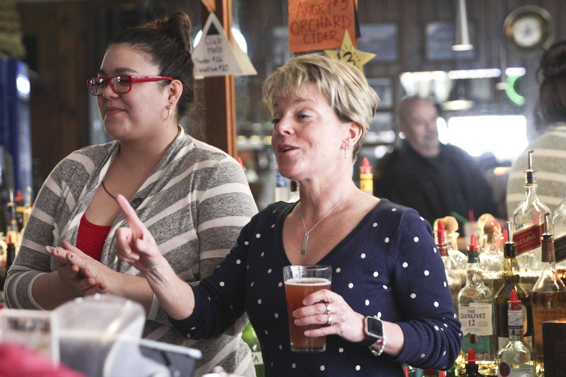 Triangle Club owner Leeann Thomas, right, and bartender Sam Sims, toast the bar at last call before an indefinite closure due to coronavirus prevention measure, March 18, 2020. (Michael S. Lockett | Juneau Empire)