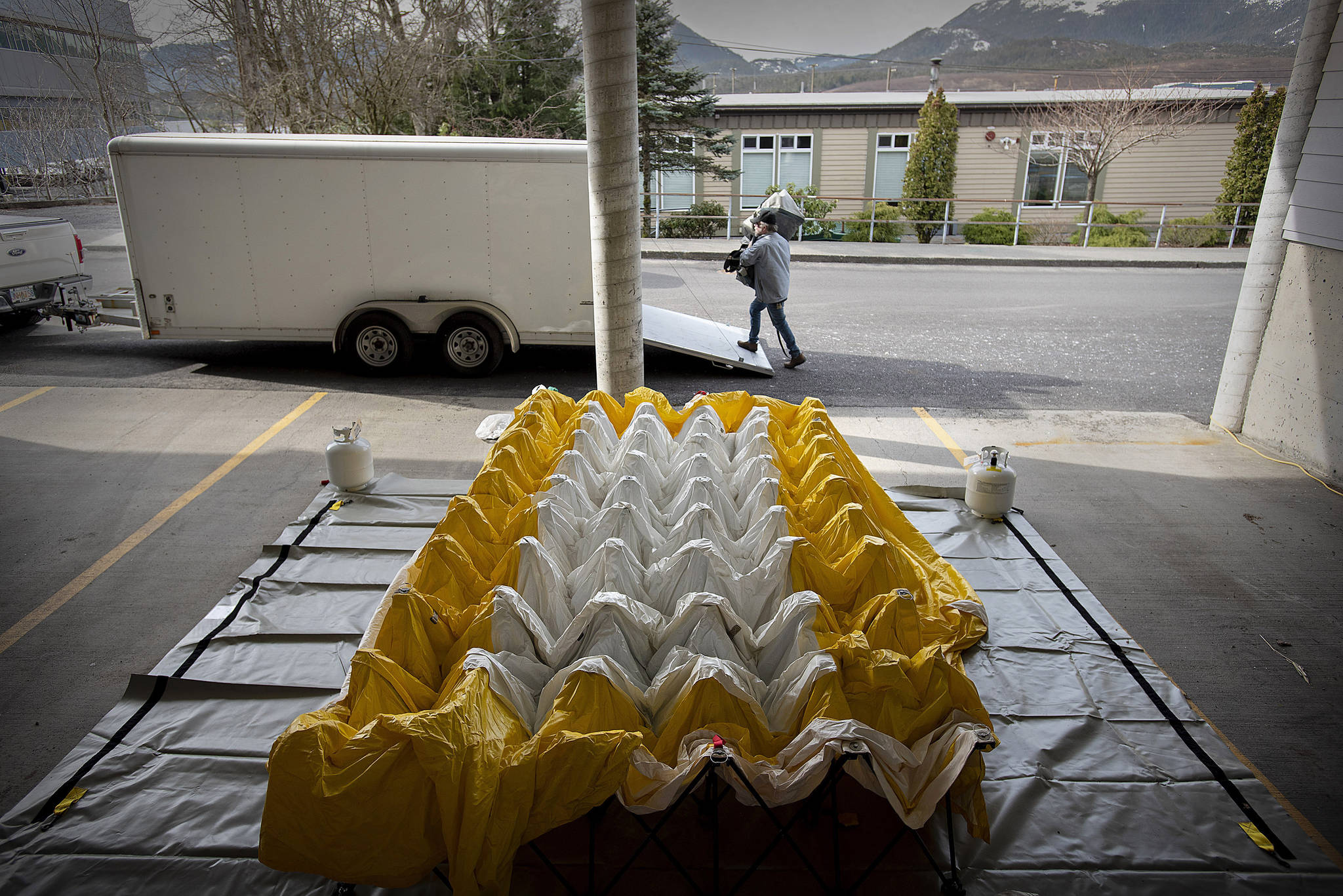 A hospital worker sets up a curbside testing area for people showing symptoms after potential contact with the new coronavirus, Wednesday, March 18, 2020. (Dustin Safranek | Ketchikan Daily News via AP)