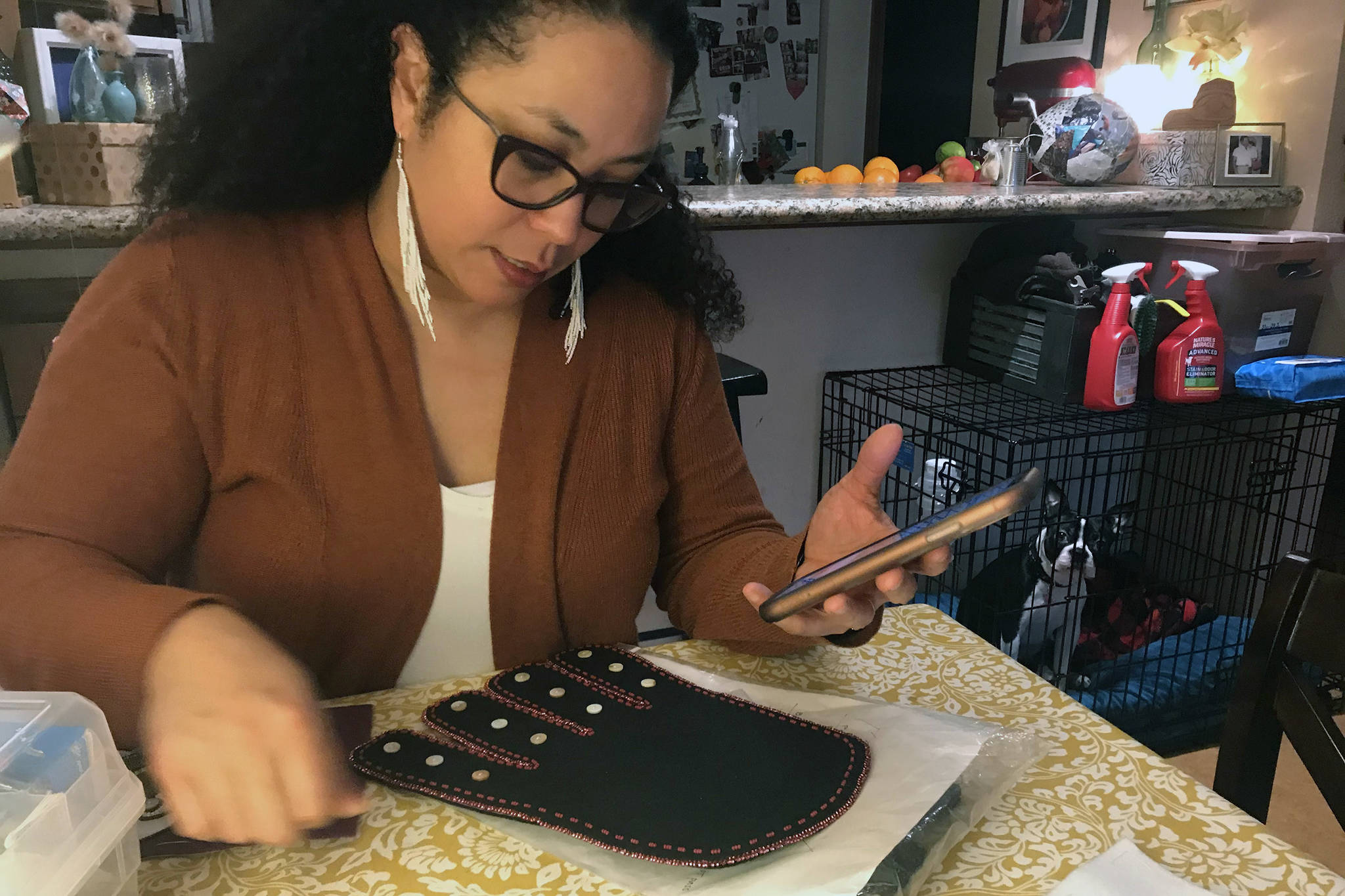 Amelia Rivera explains how to bead during an interview at her home Feb. 27. Below are the first pair of earrings she has made. (Mollie Barnes | For the Juneau Empire)