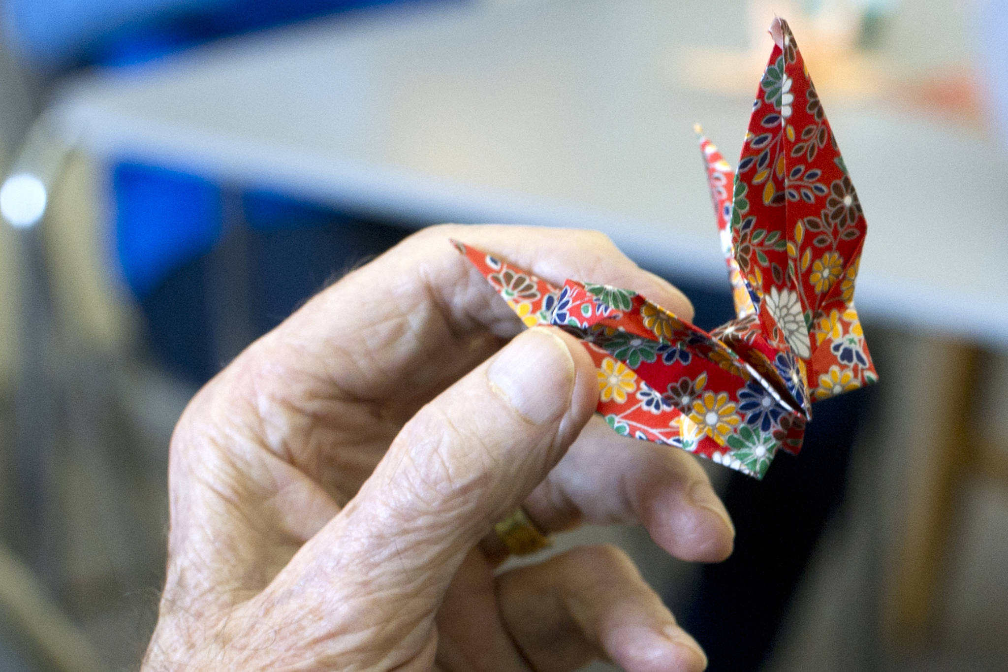 A Juneau Pioneer Home resident holds a paper crane made during a visit by Haborview Elementary School students in April 2016. (Michael Penn | Juneau Empire File)