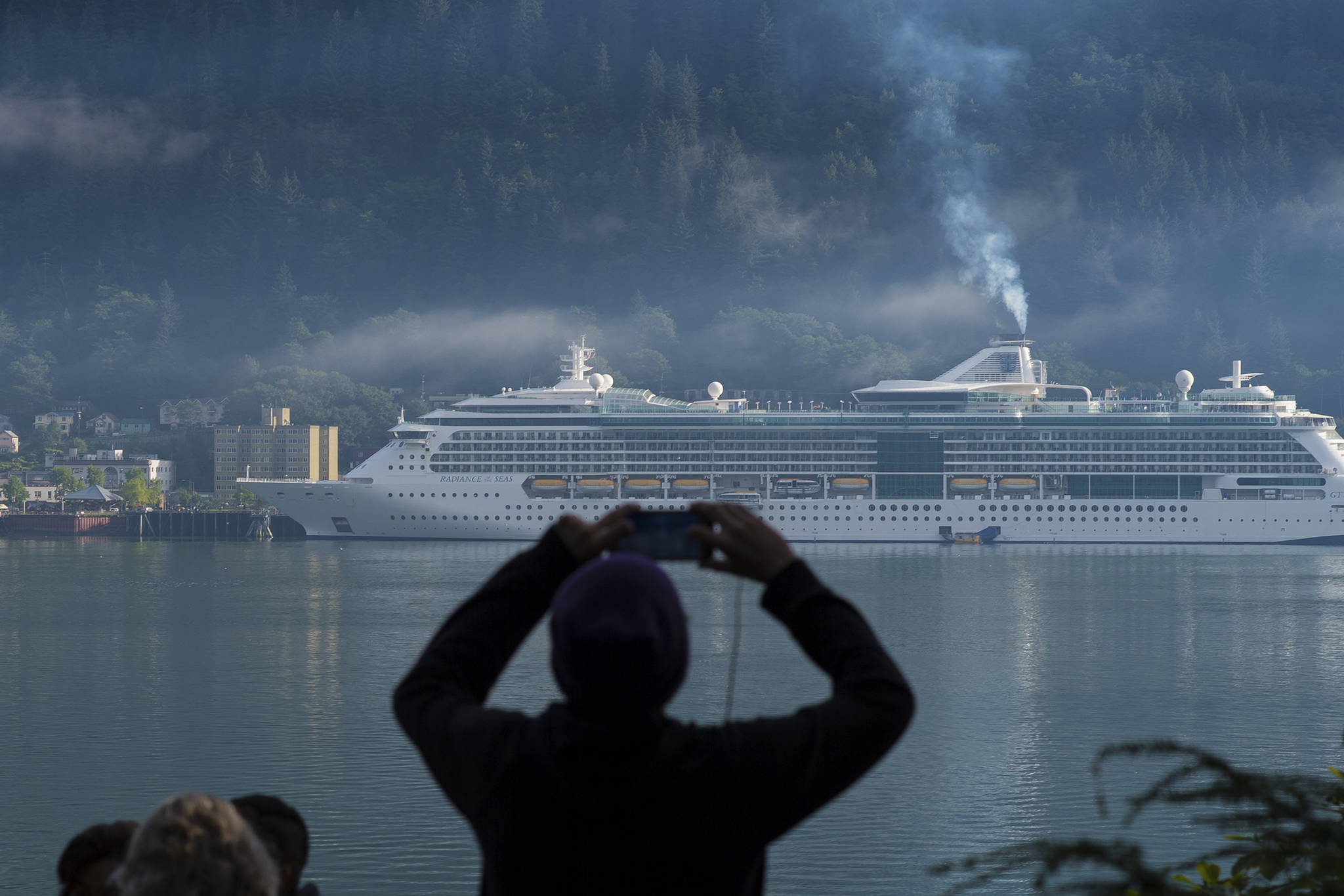 Aa cruise ship passenger photographs a ship in Juneau’s downtown harbor in August 2017. (Michal Penn | Juneau Empire File)