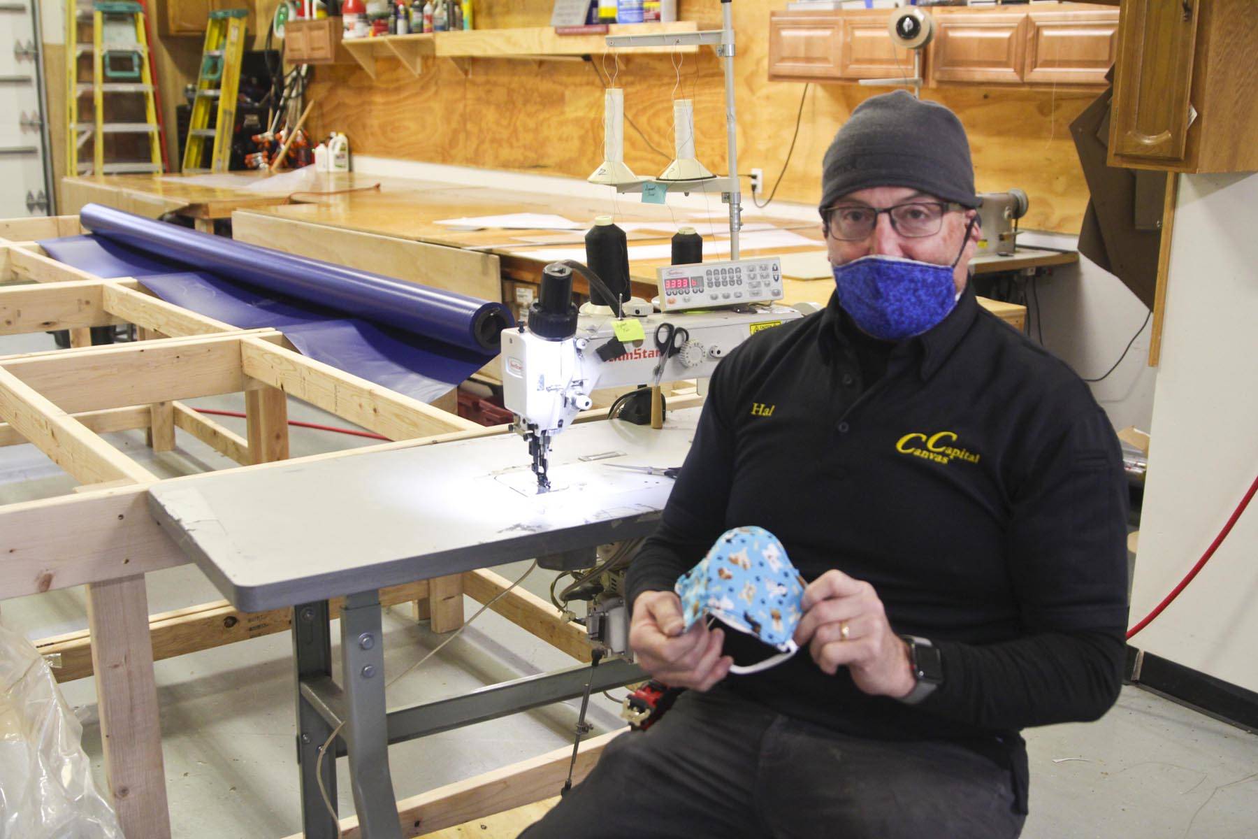 Hal Daugherty shows off his cloth mask design, to be put into production at his all-volunteer Southeast Regional Personal Protective Equipment Fabrication Facility, stood up in his sterilized workspace at Capital Canvas, March 27, 2020. (Michael S. Lockett | Juneau Empire)