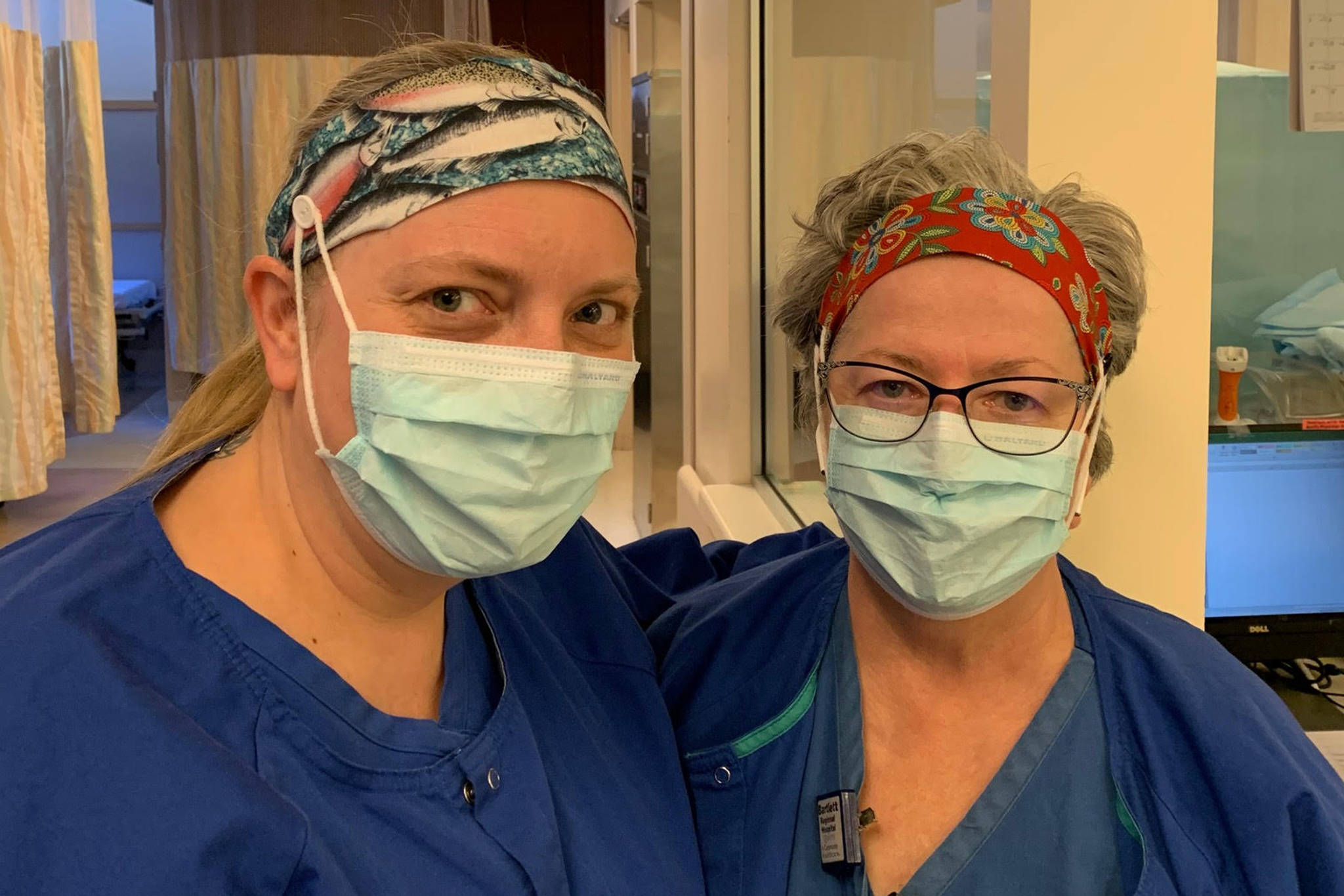 Surgical scrub technician Jody Hass and registered nurse Diana Colbert wear headbands made by Liz Clauder and her daughters, Frances Jones and Nicole Bettridge. The headbands include buttons that allow masks to loop around things that aren’t a health care worker’s ears. (Courtesy Photo | Luke Jones)