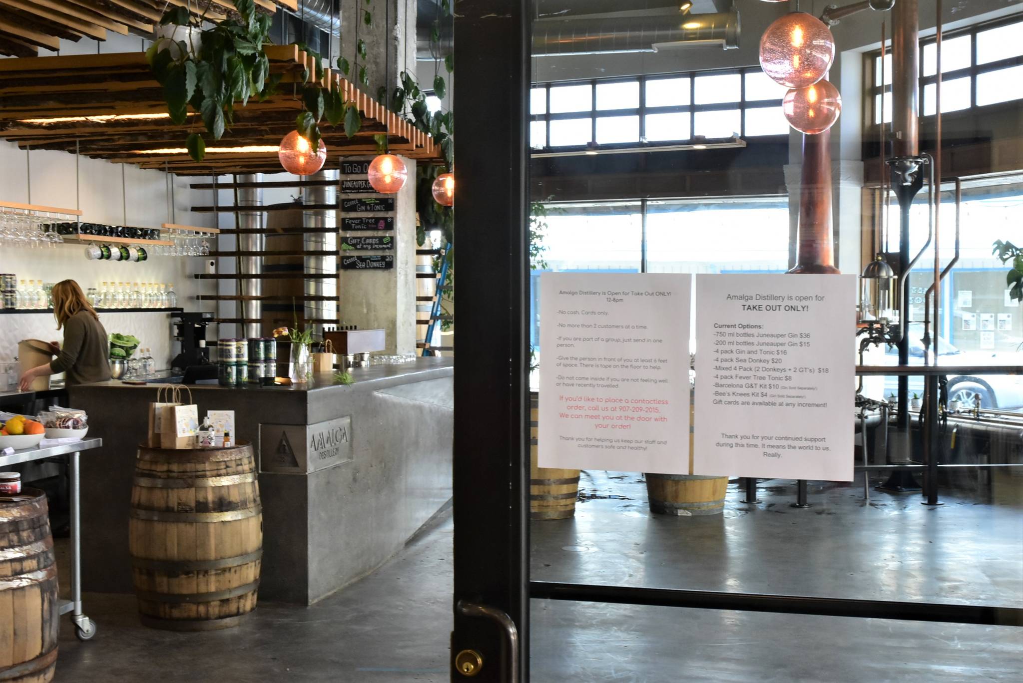 Peter Segall | Juneau Empire A sign on the door at Amalga Distillery in downtown Juneau showing items available for carry-out on Monday.