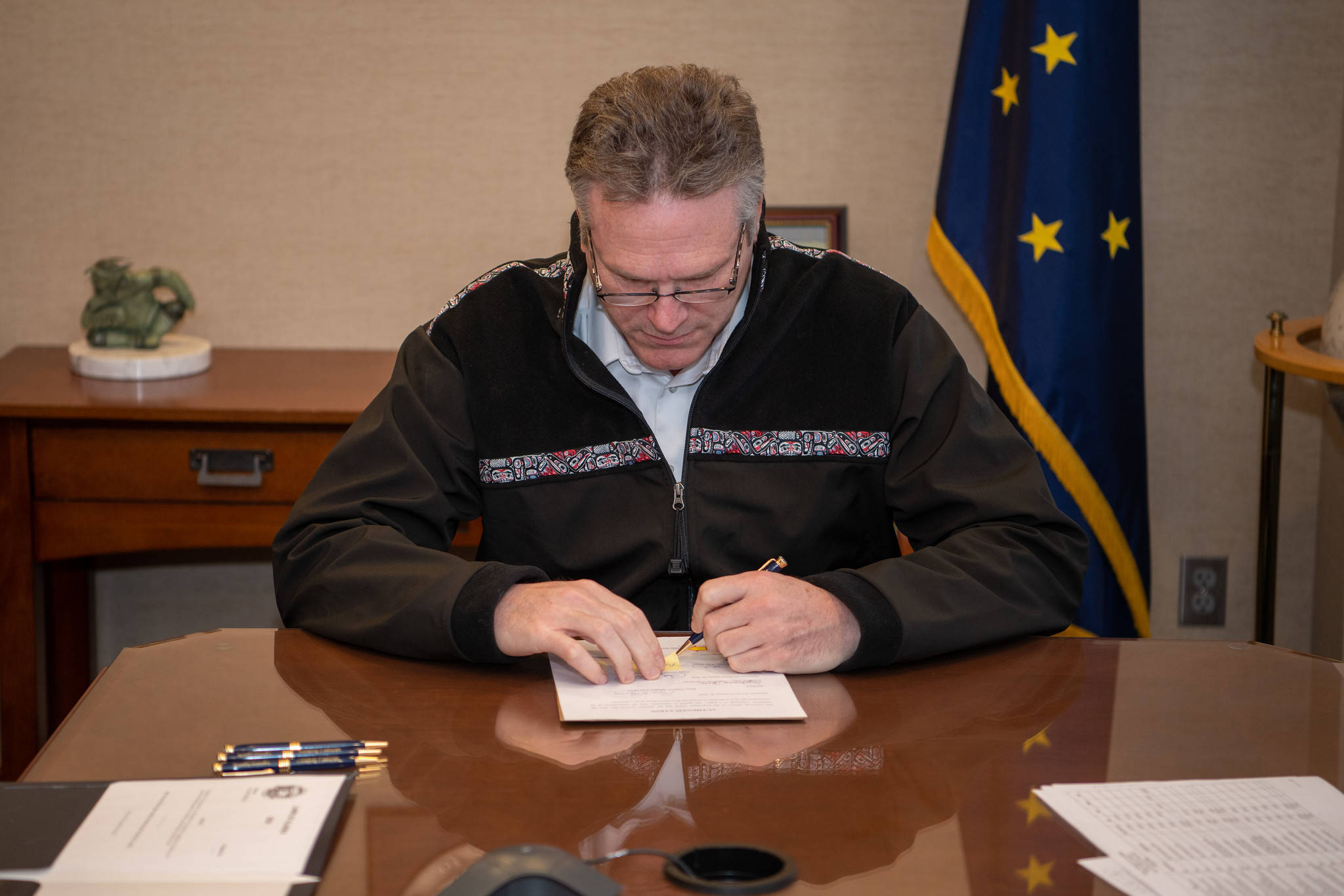 Gov. Mike Dunleavy signs the Fiscal Year 2021 budget into law in Anchorage on Monday, April 6, 2020. (Courtesy photo | Office of Gov. Mike Dunleavy)