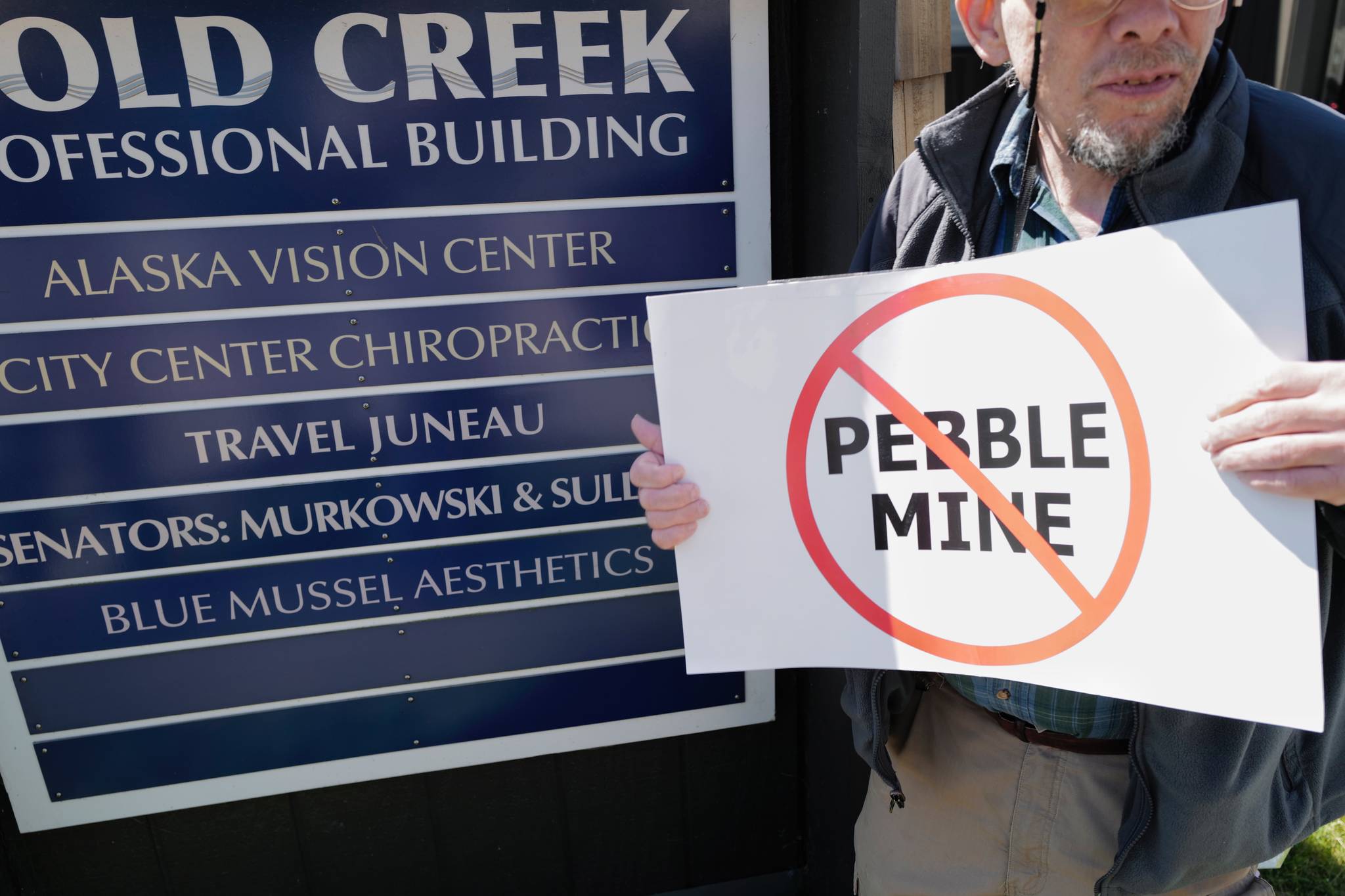 Judy Cavanaugh stands with others at a rally against the Pebble Mine in front of Sen. Lisa Murkowski’s Juneau office in July 2019. (Michael Penn | Juneau Empire File)
