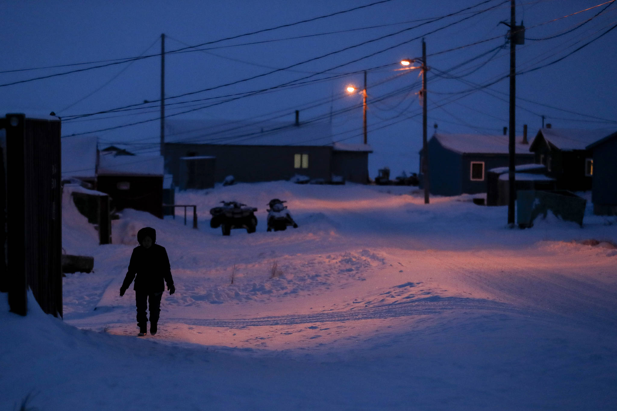 In this January photo, a woman walks before dawn in Toksook Bay. Native American leaders are raising questions about how $8 billion in federal coronavirus relief tagged for tribes will be distributed, with some arguing that for-profit Alaska Native corporations shouldn’t get a share of the funding. (AP Photo | Gregory Bull, File)