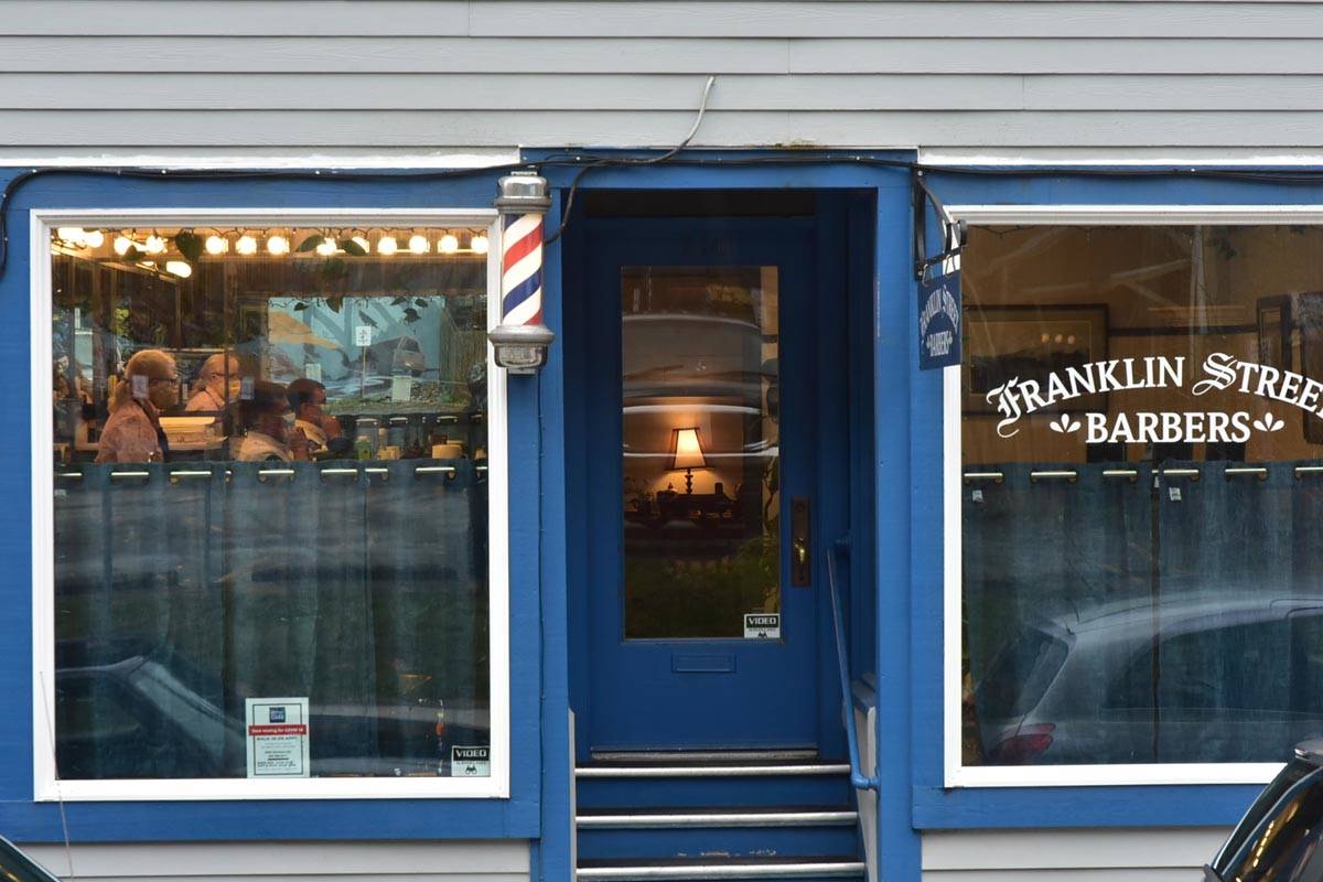Mindy Roggenkamp, co-owner of Franklin Street Barbers, cuts hair while wearing her personal protective equipment on Friday, April 24, 2020. She already has reservations booked two weeks ahead, but under the new regulations only one barber can be working in their shop at a time. (Peter Segall | Juneau Empire)