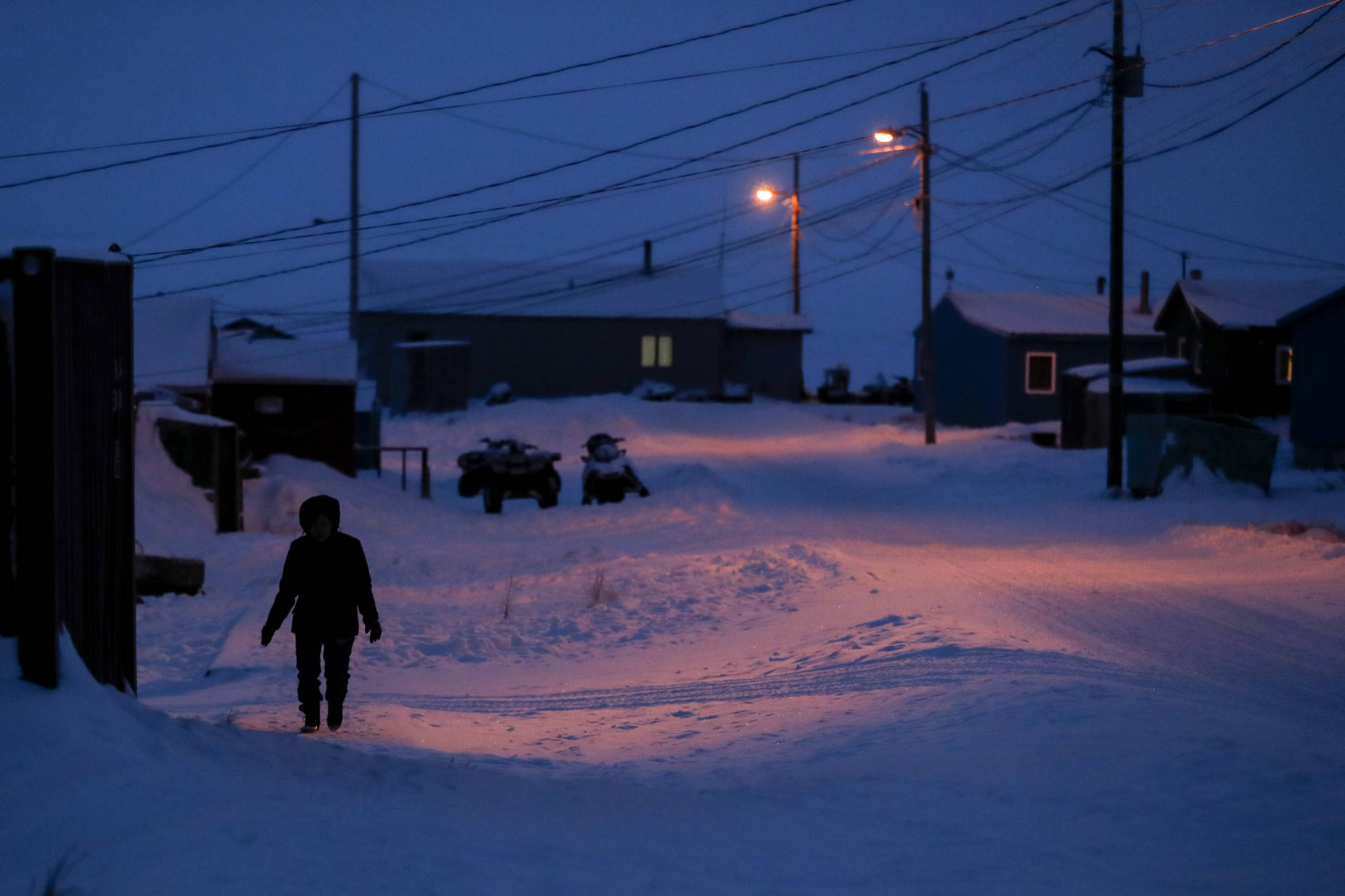 A woman walks before dawn in Toksook Bay, Alaska, a mostly Yup’ik village on the edge of the Bering Sea. A judge has ruled in favor of tribal nations in their bid to keep Alaska Native corporations from getting a share of $8 billion in coronavirus relief funding — at least for now. In a decision issued late Monday, April 27, 2020, U.S. District Judge Amit Mehta in Washington, D.C., said the U.S. Treasury Department could begin disbursing funding to 574 federally recognized tribes to respond to the coronavirus but not to the corporations .(AP Photo | Gregory Bull, File)